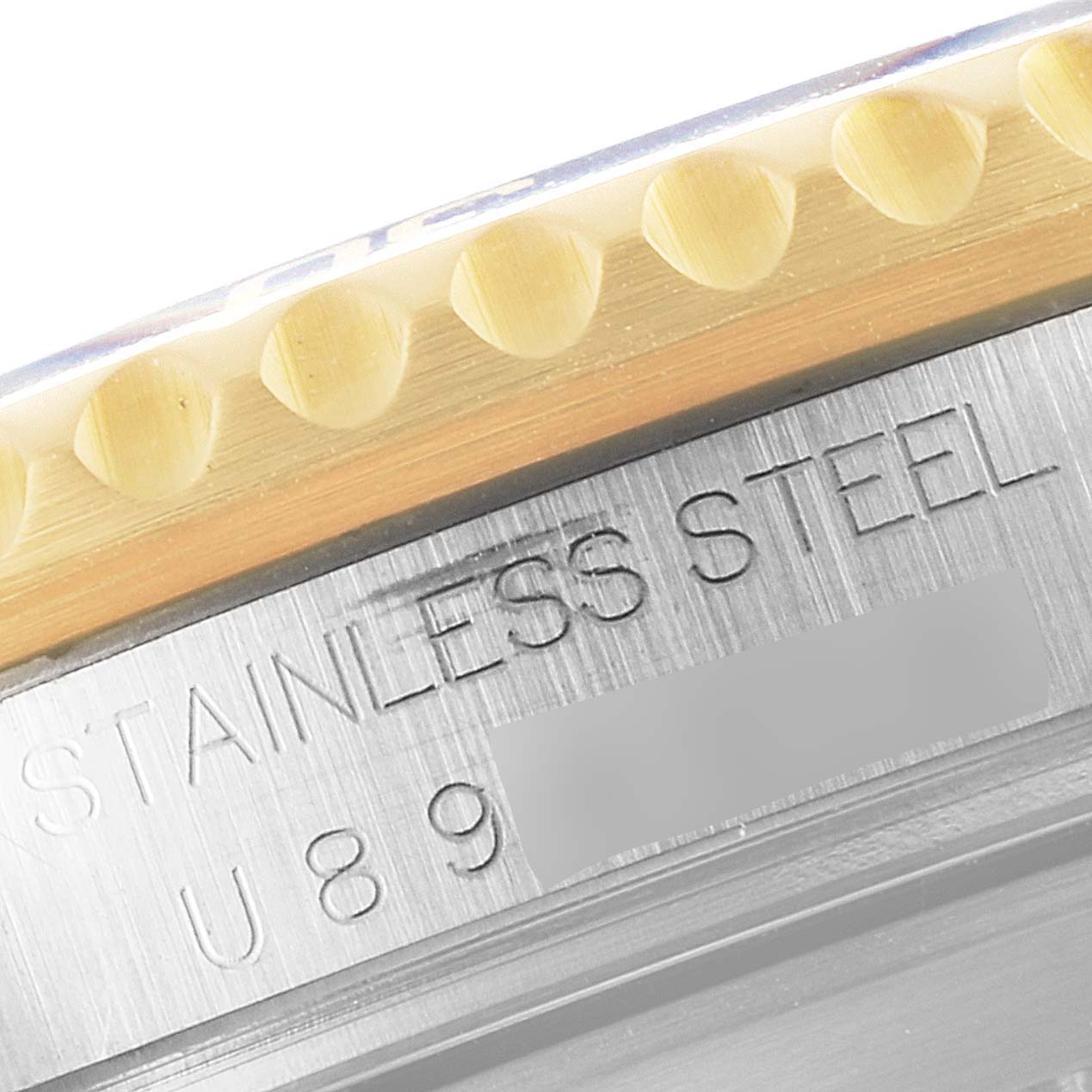 This image shows a macro close-up view of the Rolex Submariner 16613 Men's Steel and Gold (two tone) Blue Dial 16613 Men's Steel and Gold (two tone) Blue Dial's stainless steel case and part of its bezel.