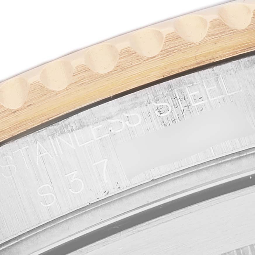 This image shows a close-up of the edge and partial engravings on the bezel and casing of a Rolex Submariner 16613 Men's Steel and Gold (two tone) Blue Dial 16613 Men's Steel and Gold (two tone) Blue Dial watch.