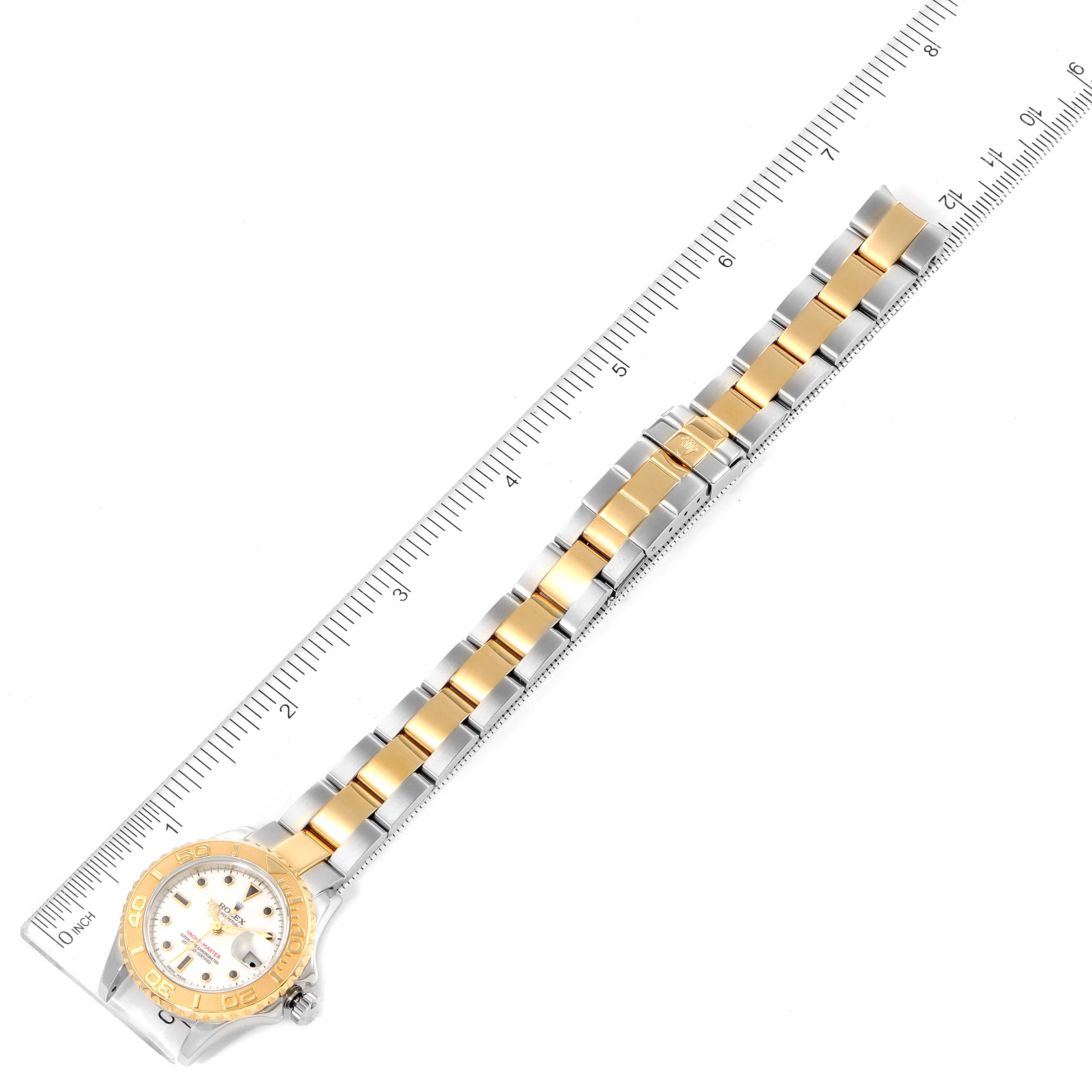 This image shows the Yacht-Master model by Rolex from a top-down angle, displaying the watch face, bezel, and bracelet against a ruler.