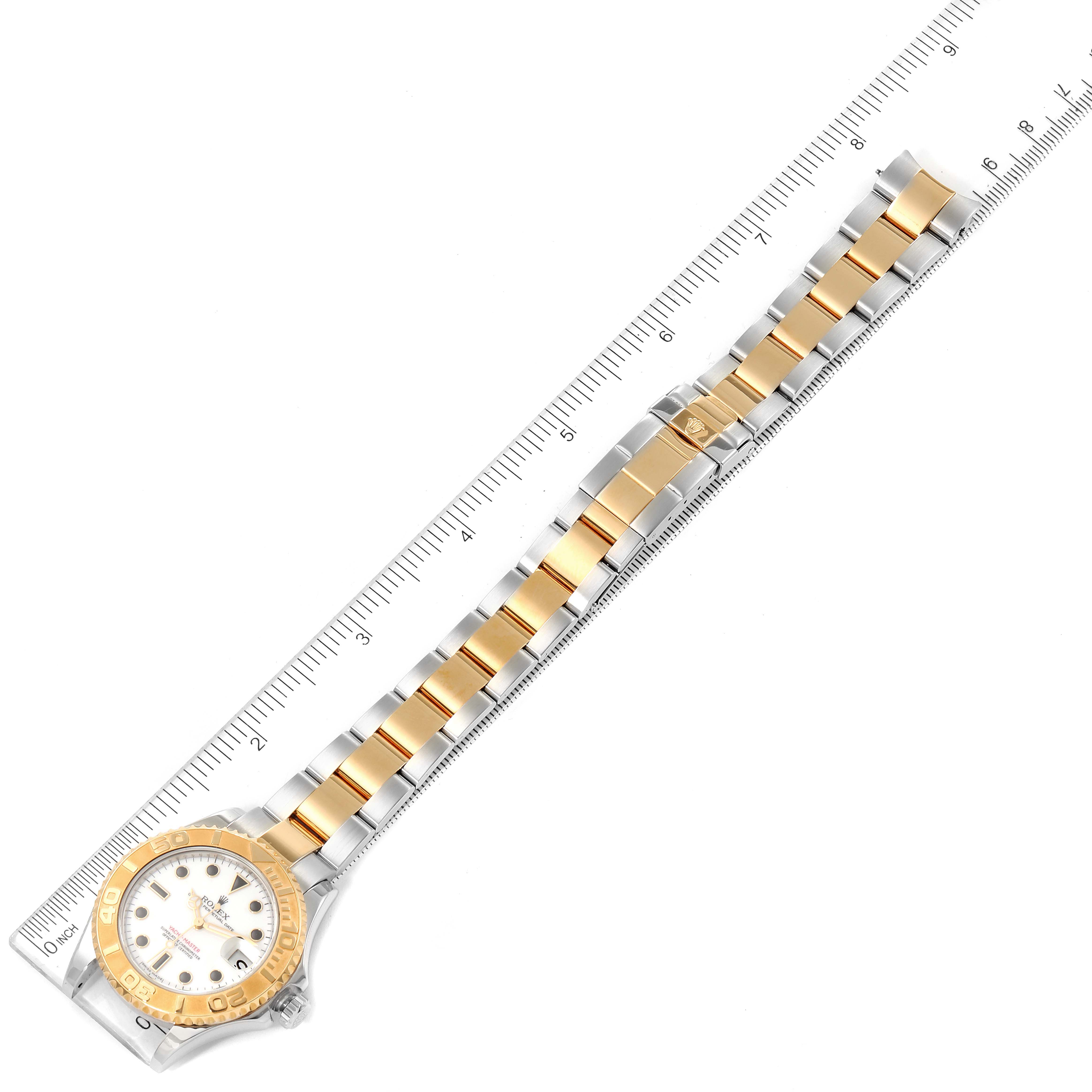 The image shows a full view of a Rolex Yacht-Master 168623 Men
s Steel and Gold (two tone) White Dial 168623 Men
s Steel and Gold (two tone) White Dial watch with its band extended next to a ruler.