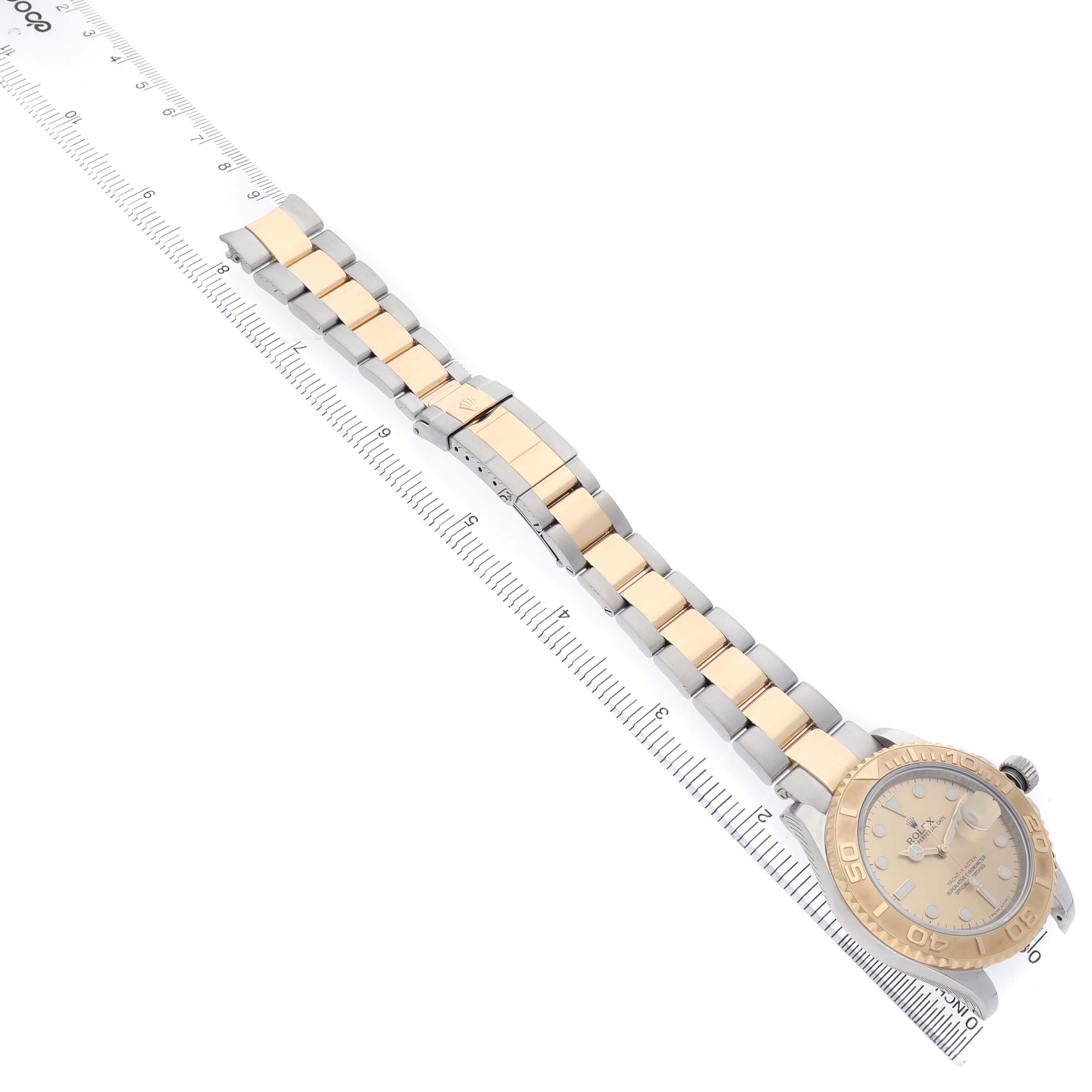 The Rolex Yacht-Master 16623 Men's Stainless Steel Champagne Dial watch is shown at an angle highlighting the bracelet, bezel, and face alongside a ruler.