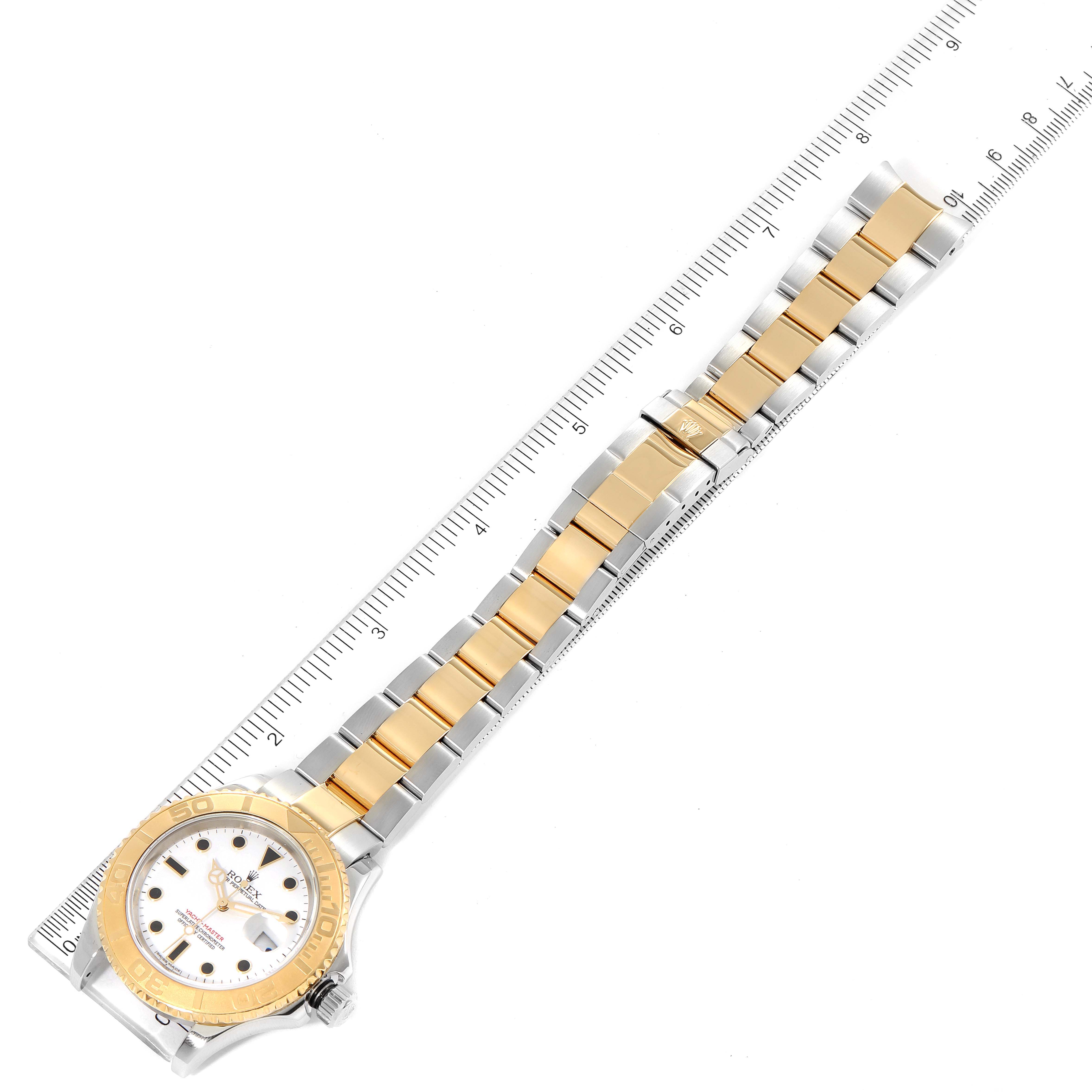 The Rolex Yacht-Master 16623 Men
s Steel and Gold (two tone) White Dial 16623 Men
s Steel and Gold (two tone) White Dial watch is shown fully extended, displaying the face, bezel, and bracelet, with a ruler for scale.