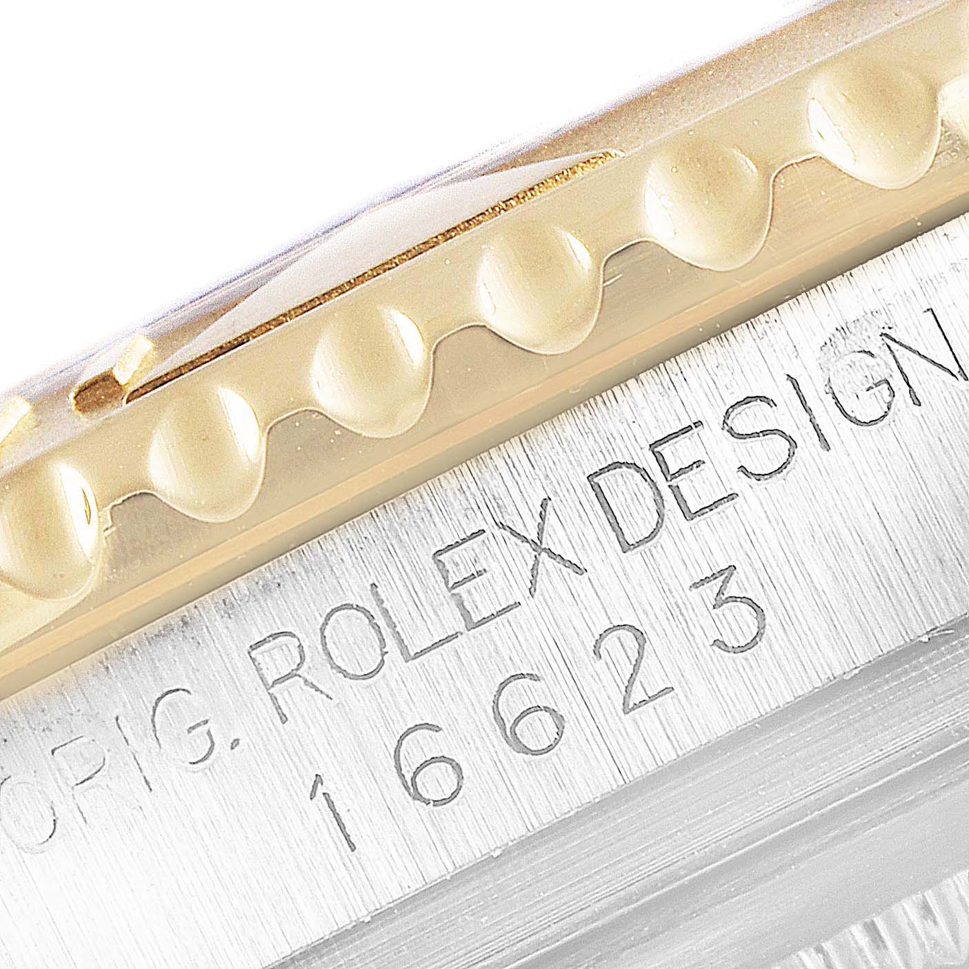 This close-up of a Rolex Yacht-Master 16623 Men
s Steel and Gold (two tone) White Dial 16623 Men
s Steel and Gold (two tone) White Dial watch shows the engraved model number "16623" and part of the bezel.