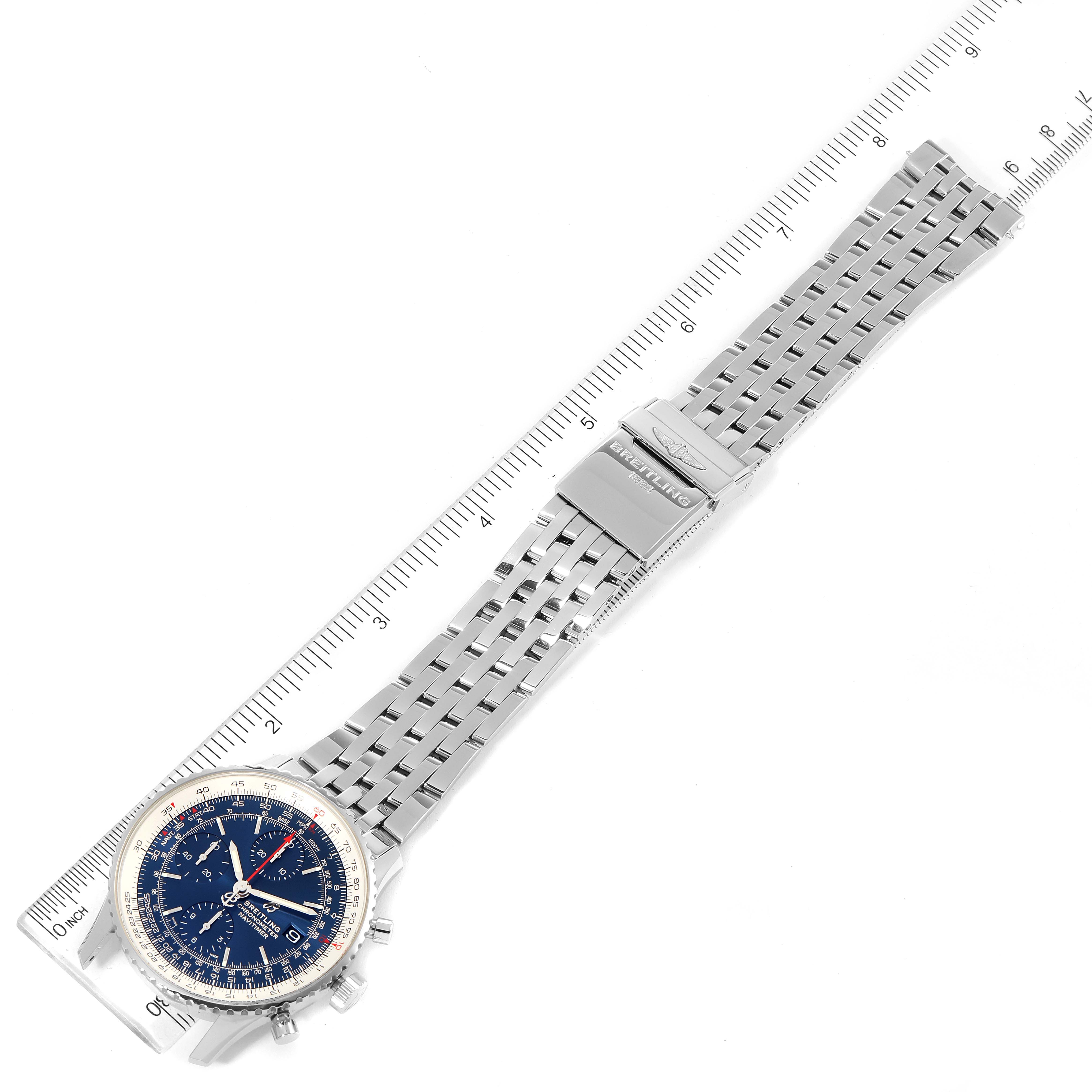 The image shows a top-down view of a Breitling Navitimer A13324 Men
s Stainless Steel Blue Dial A13324 Men
s Stainless Steel Blue Dial watch, highlighting its face, stainless steel bracelet, and clasp with a ruler for scale.