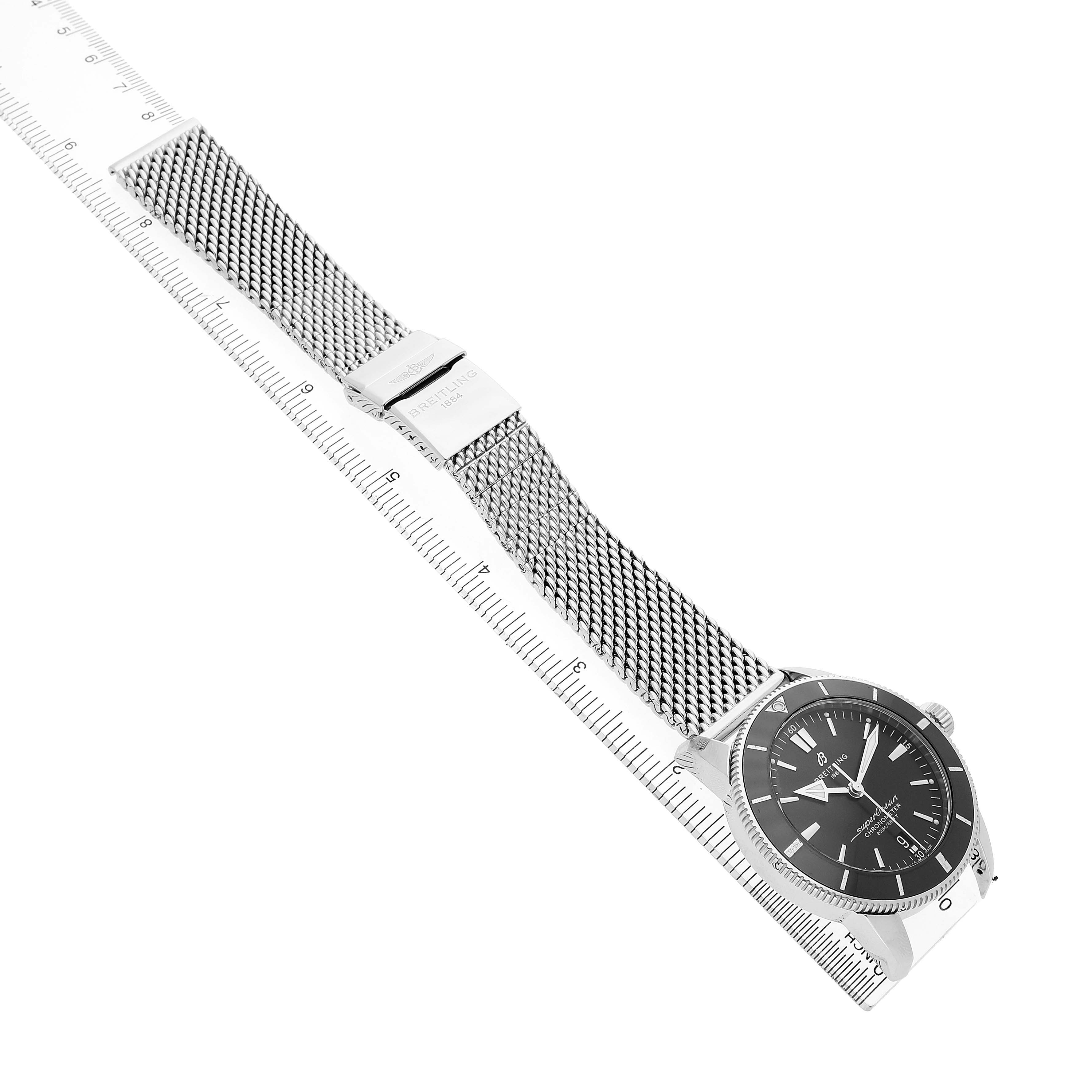 The Breitling Superocean AB2030 Men's Stainless Steel Black Dial watch is shown at a diagonal angle, displaying the face, bezel, mesh strap, and part of the clasp.