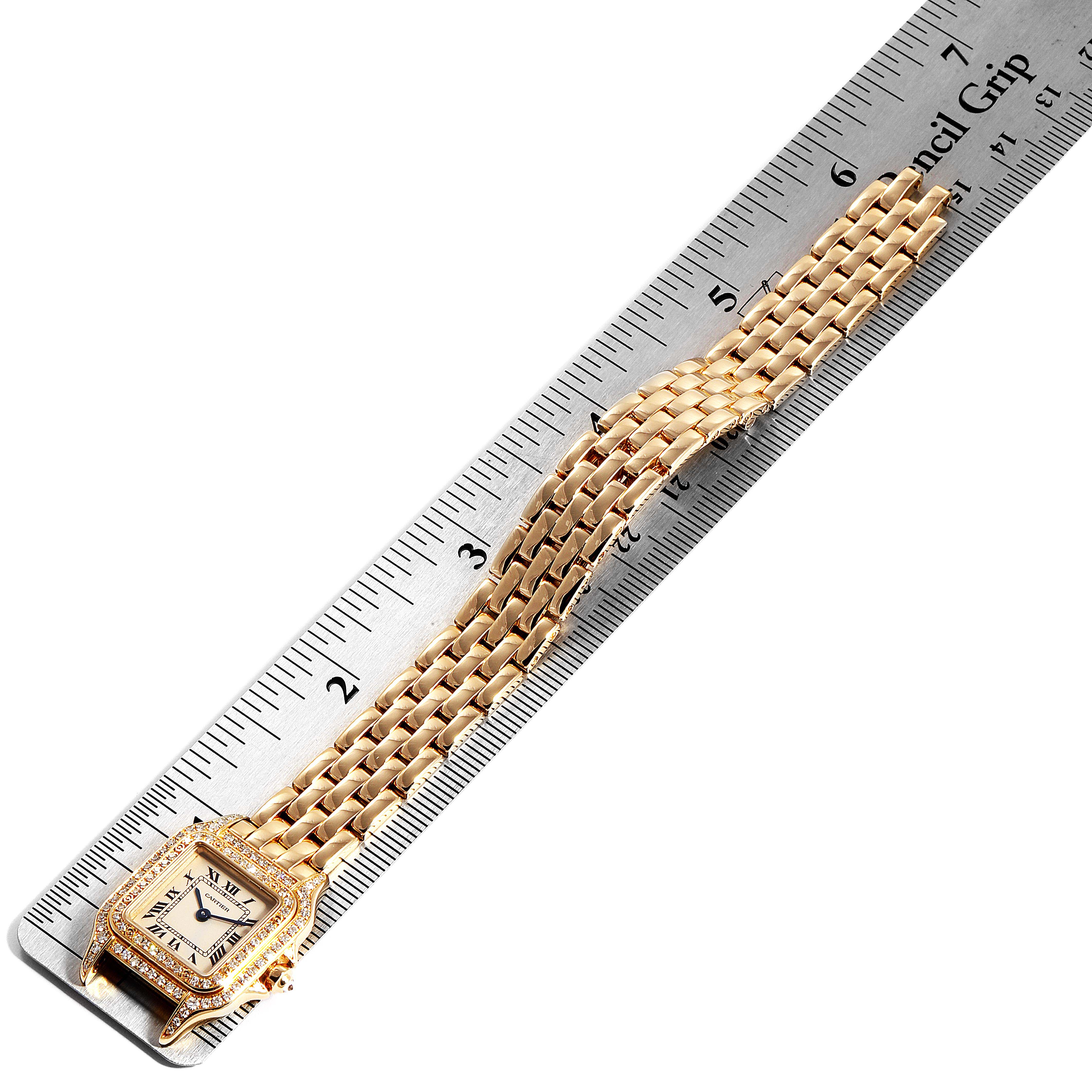 The image shows a top-down view of a Cartier Panthere WF3072B9 Women's Yellow Gold Silver Dial WF3072B9 Women's Yellow Gold Silver Dial watch with a gold bracelet next to a ruler for scale.