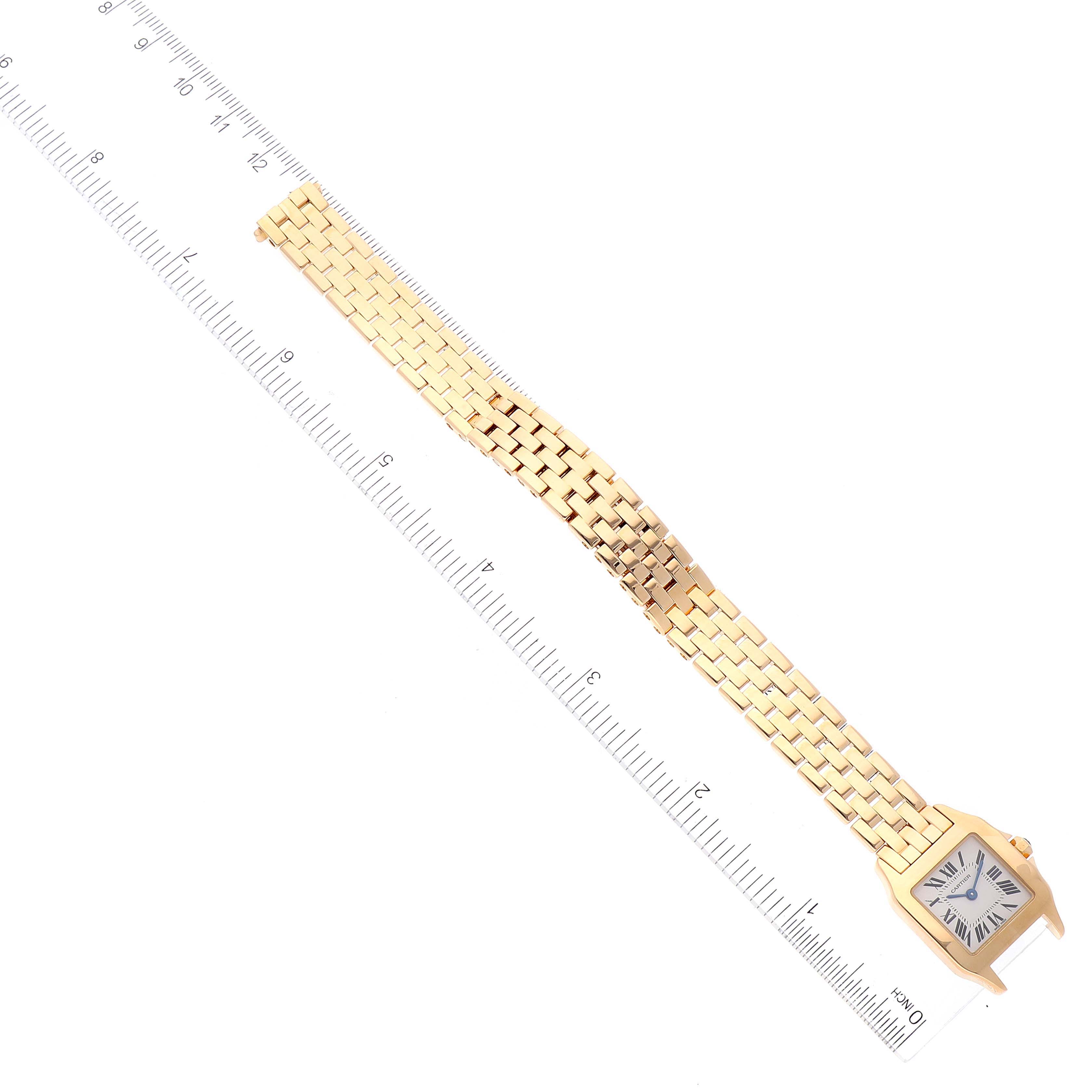 The Cartier Santos Demoiselle W25063X9 Women
s Yellow Gold Silver Dial W25063X9 Women
s Yellow Gold Silver Dial watch is shown from an overhead angle, displaying the entire watch with a ruler for size reference.