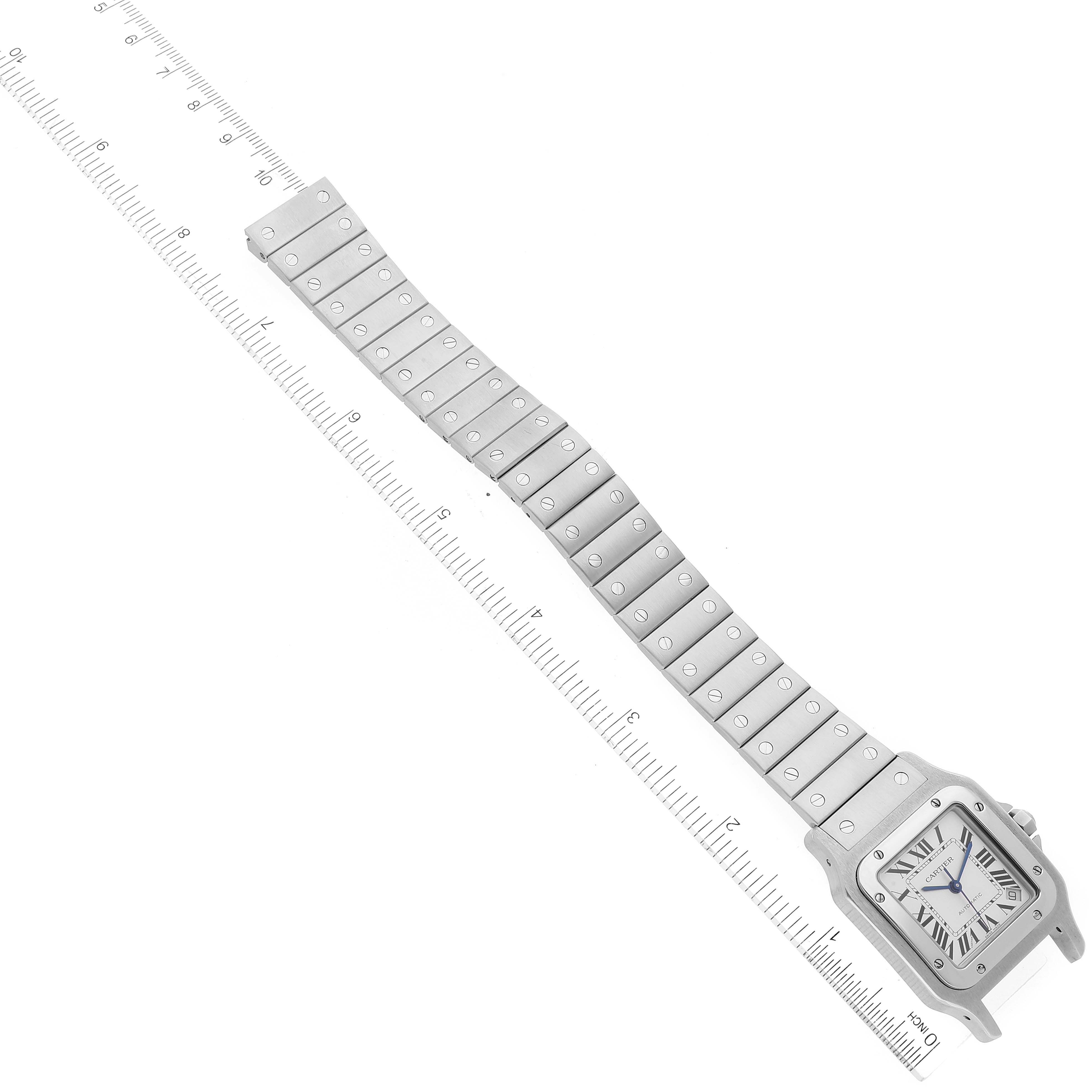 The image shows the Santos model by Cartier, displayed flat with its full bracelet and face visible, alongside a ruler for size reference.