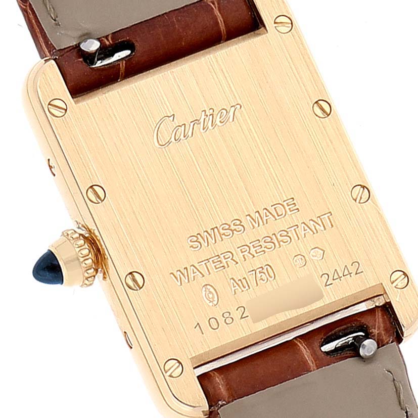 This image displays the back of the Tank Louis watch by Cartier, focusing on its inscriptions and part of the strap attachment.