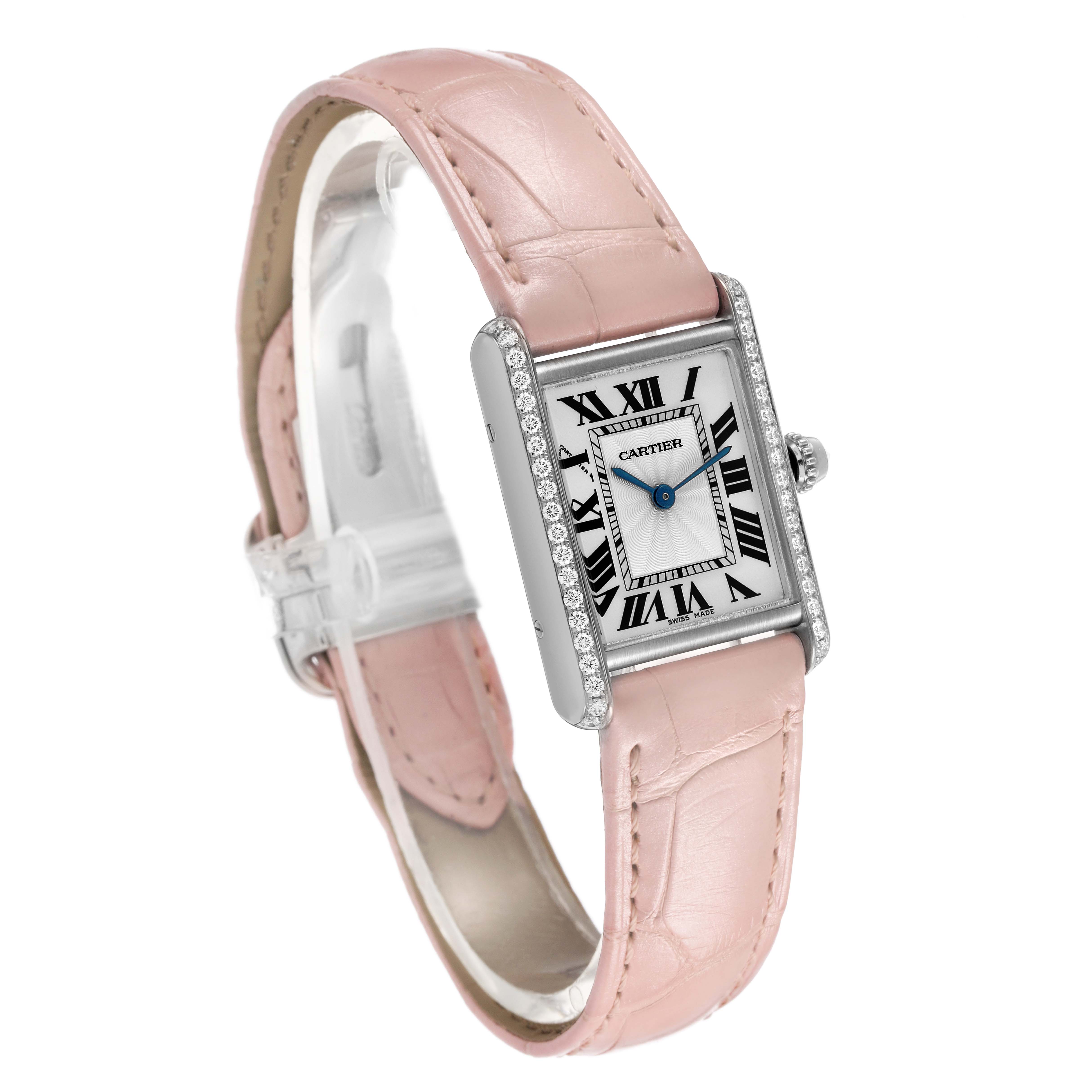 The Cartier Tank Louis WJTA0011 Women's White Gold Silver Dial watch is shown at a three-quarter angle, highlighting its pink leather strap and diamond-encrusted case.