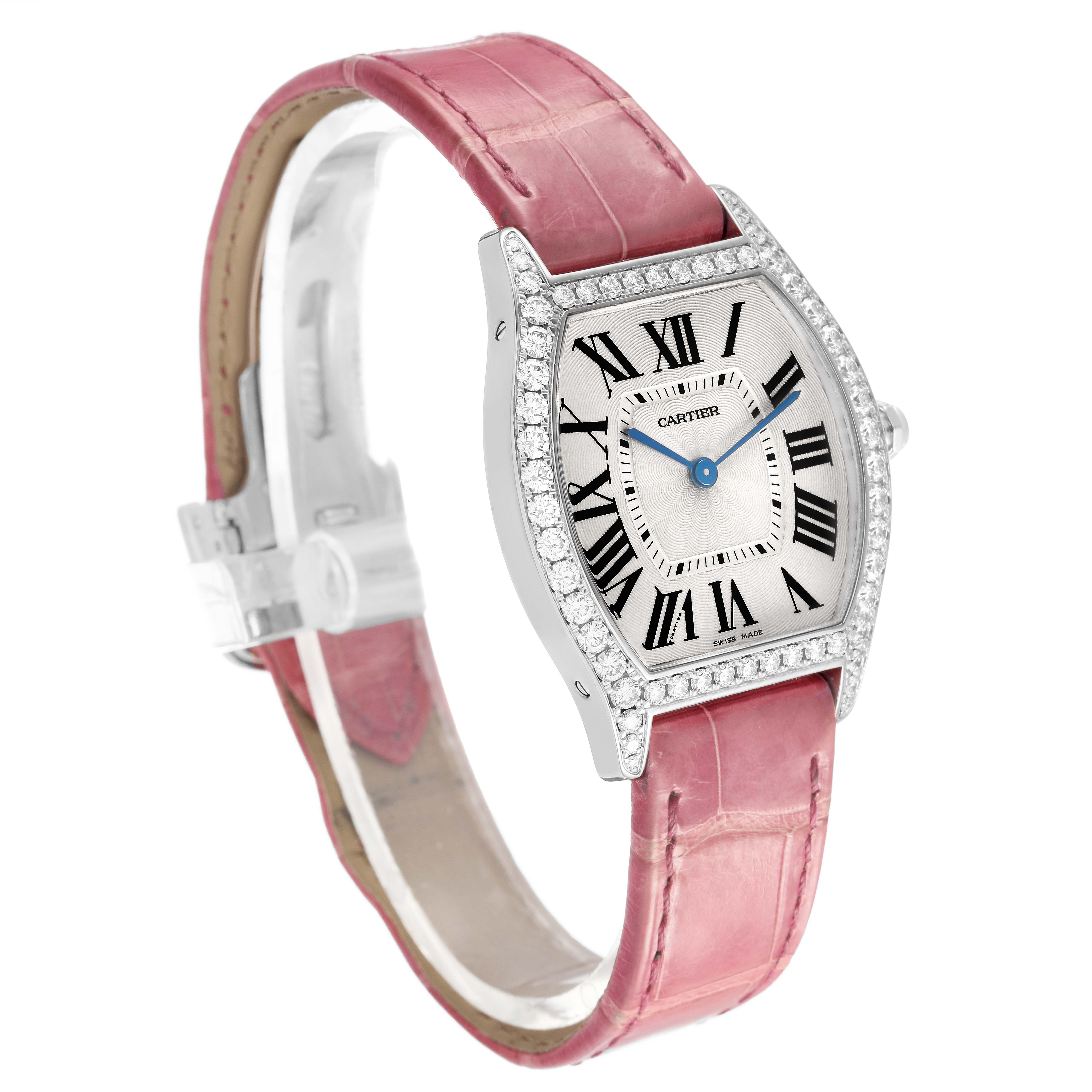 The Cartier Tortue WA501009 Women's White Gold Silver Dial watch is shown at a three-quarter angle, displaying the pink strap, diamond bezel, and Roman numeral dial.
