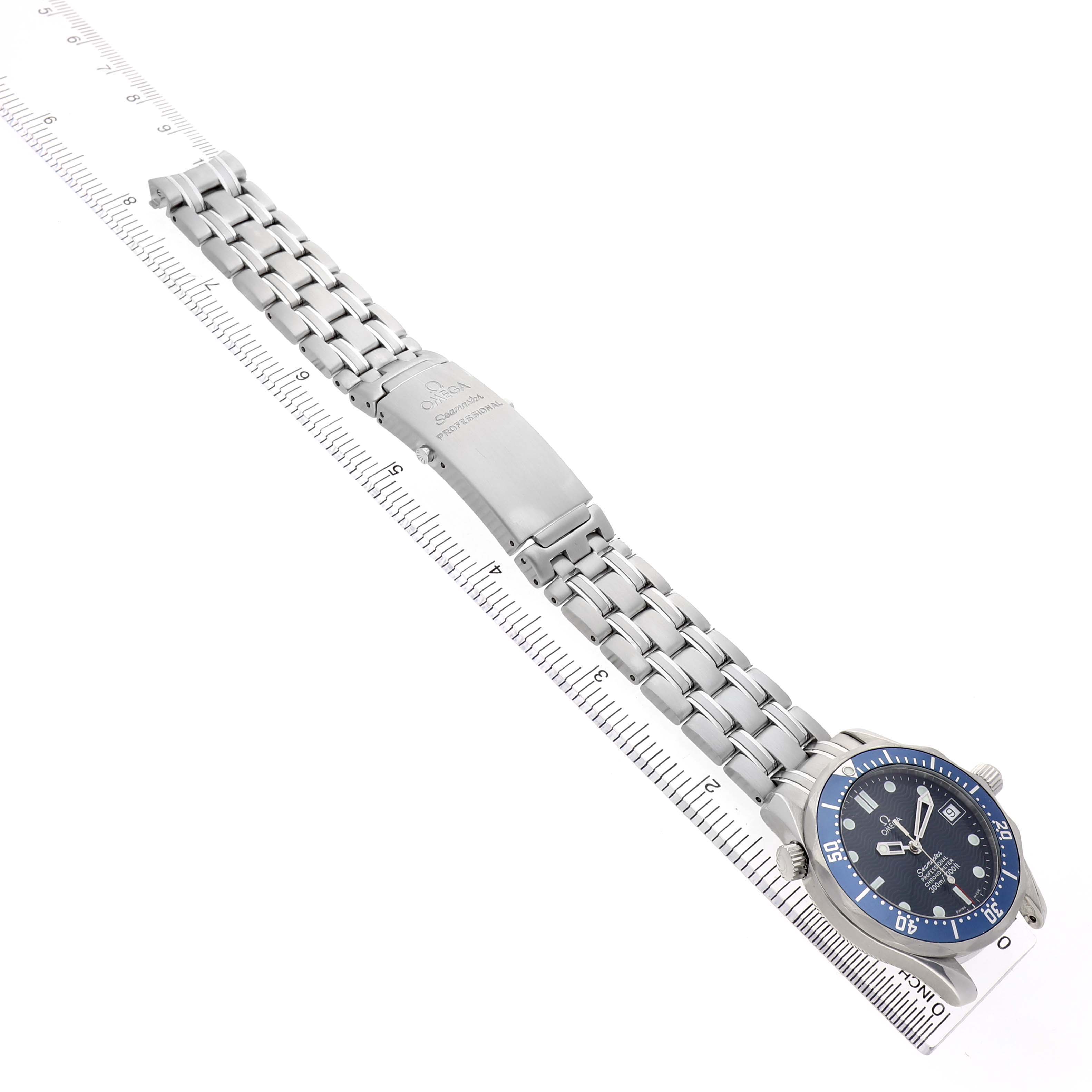 The Omega Seamaster 2551.80.00 Men's Stainless Steel Blue Dial watch is displayed flat with the face visible and the metal bracelet extended alongside a ruler.