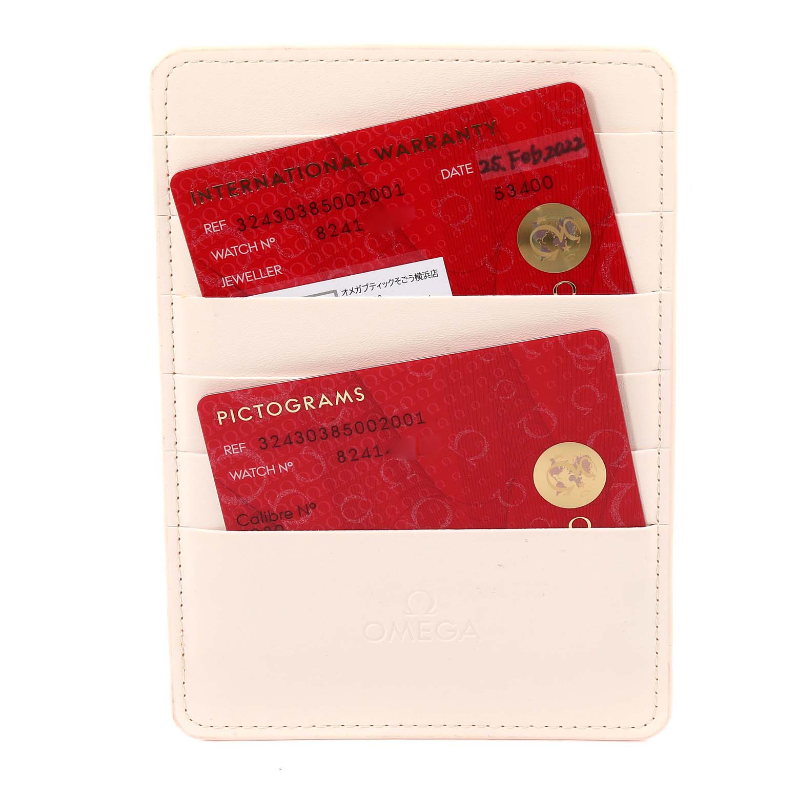 The image shows two red cards labeled "International Warranty" and "Pictograms" inside a white Omega cardholder for a Speedmaster model by Omega.