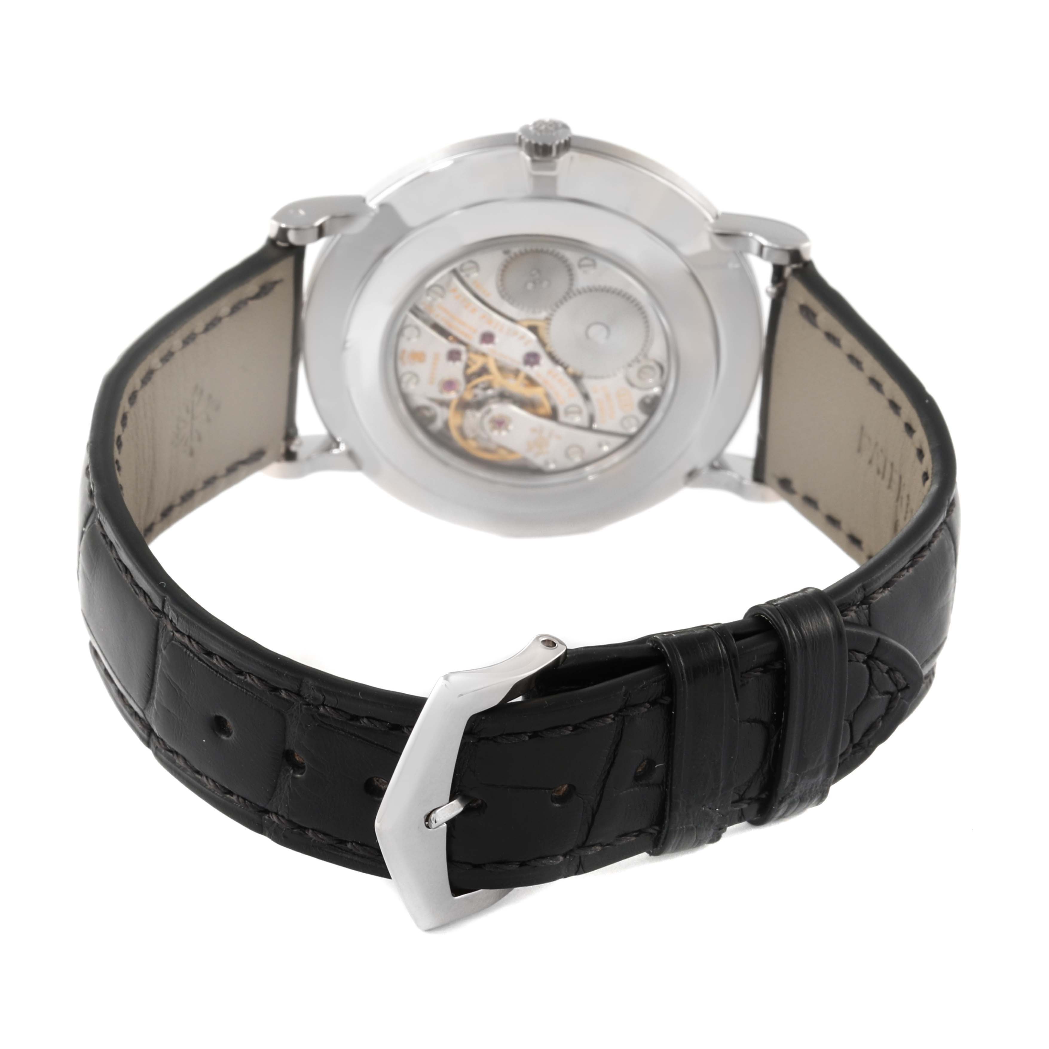 The image shows the back view of a Patek Philippe Calatrava 5119G Men's White Gold White Dial 5119G Men's White Gold White Dial watch, highlighting the inner mechanism and the black leather strap with a buckle.