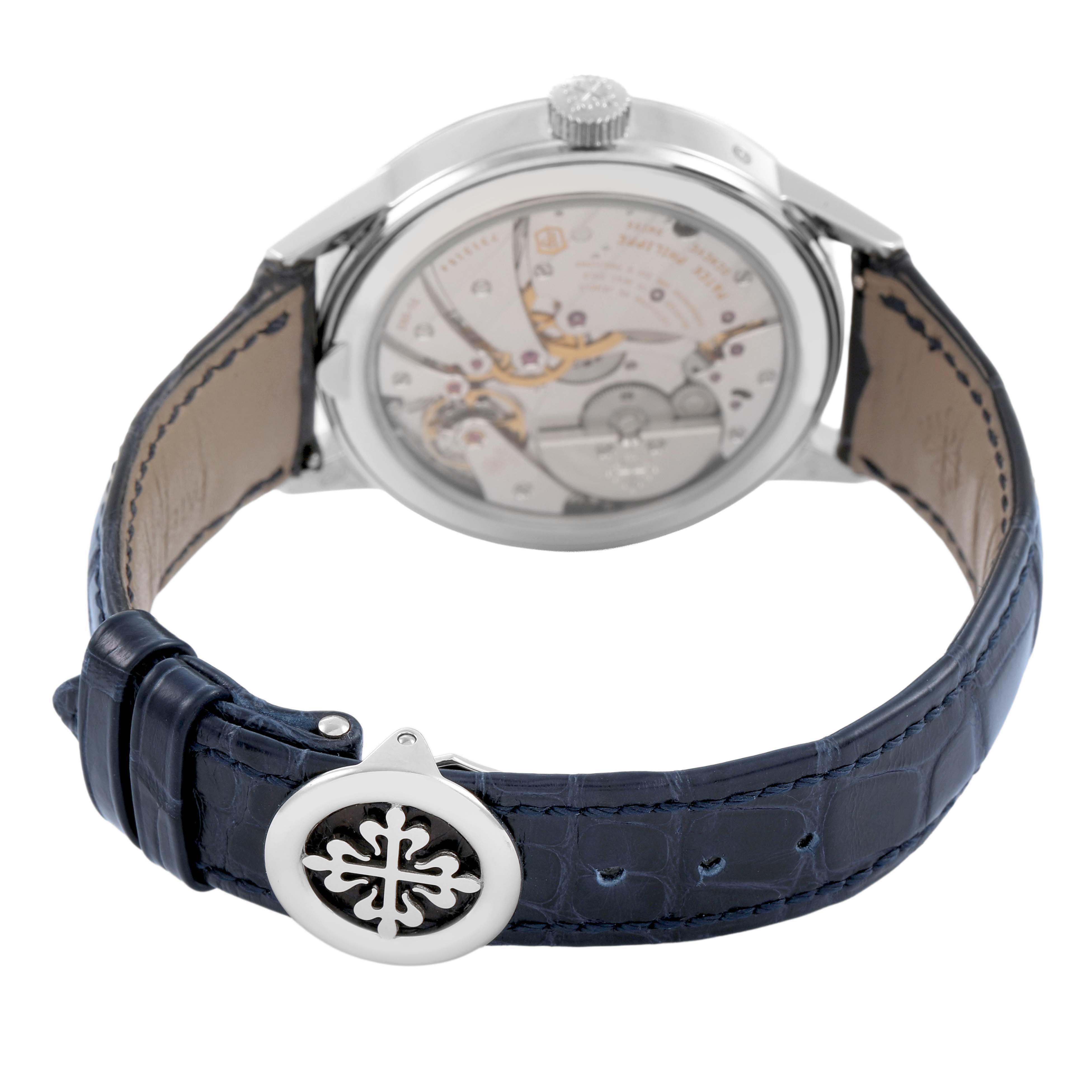 The image shows the Patek Philippe Complications 5236P-001 Men's Platinum Blue Dial watch from the back, highlighting its movement and blue leather strap.
