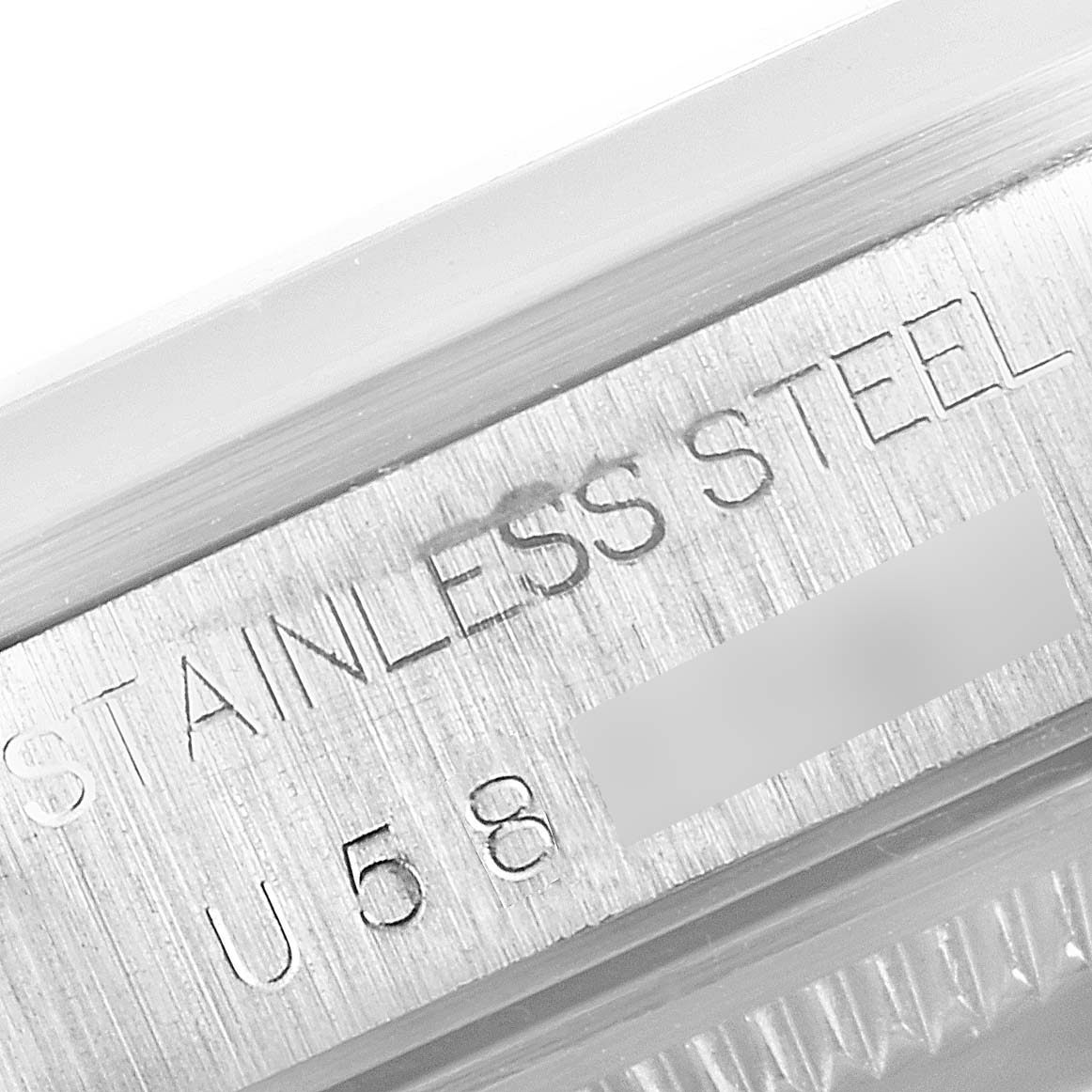 The image shows a close-up of the case side engraving on a Rolex Date 15200 Men's Stainless Steel Pink Dial 15200 Men's Stainless Steel Pink Dial model, indicating "STAINLESS STEEL."