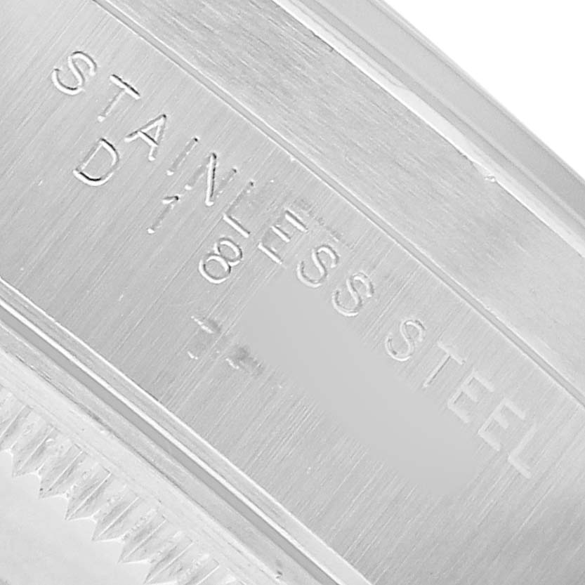 The image shows a close-up of a Rolex Date 15210 Men's Stainless Steel Black Dial model's side, focusing on "Stainless Steel" engraving.