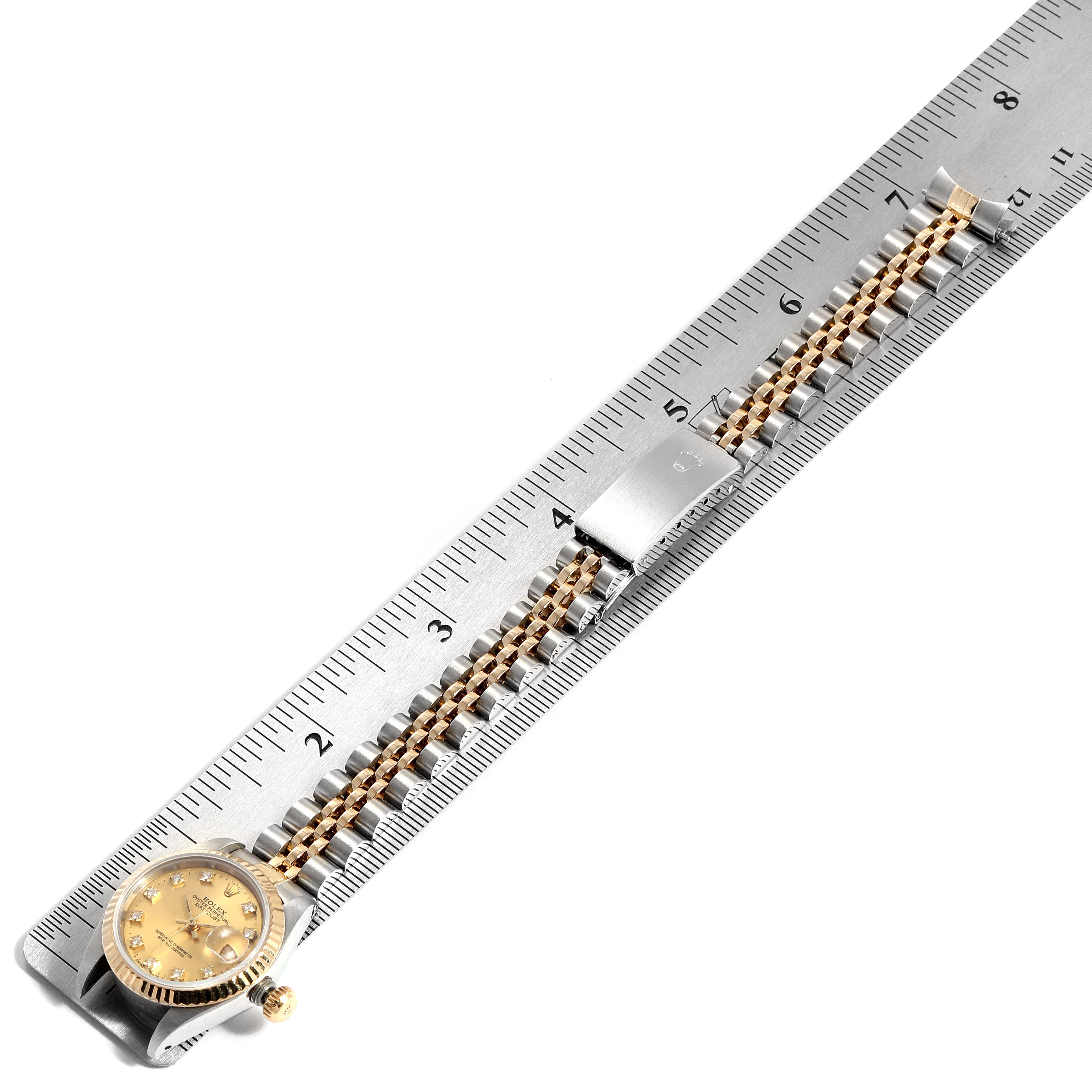 This image shows a Rolex Datejust 69173 Women
s Steel and Gold (two tone) Champagne Dial 69173 Women
s Steel and Gold (two tone) Champagne Dial watch from a top-down angle, with a focus on the dial, bezel, and bracelet placed next to a ruler.