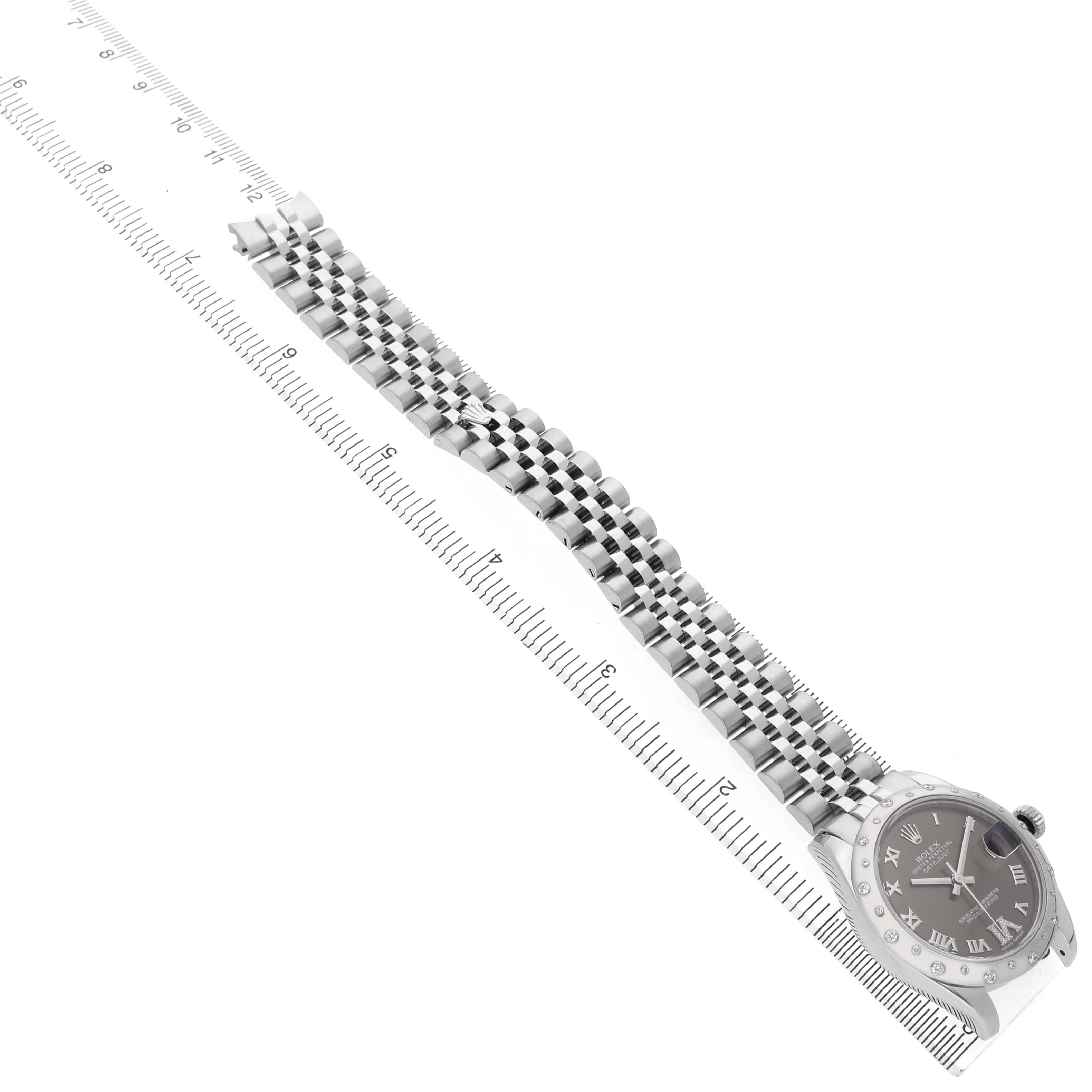 The Rolex Datejust 178344 Women's Stainless Steel Brown Dial watch is shown at an angled top view, highlighting the bracelet and bezel with a measuring scale.