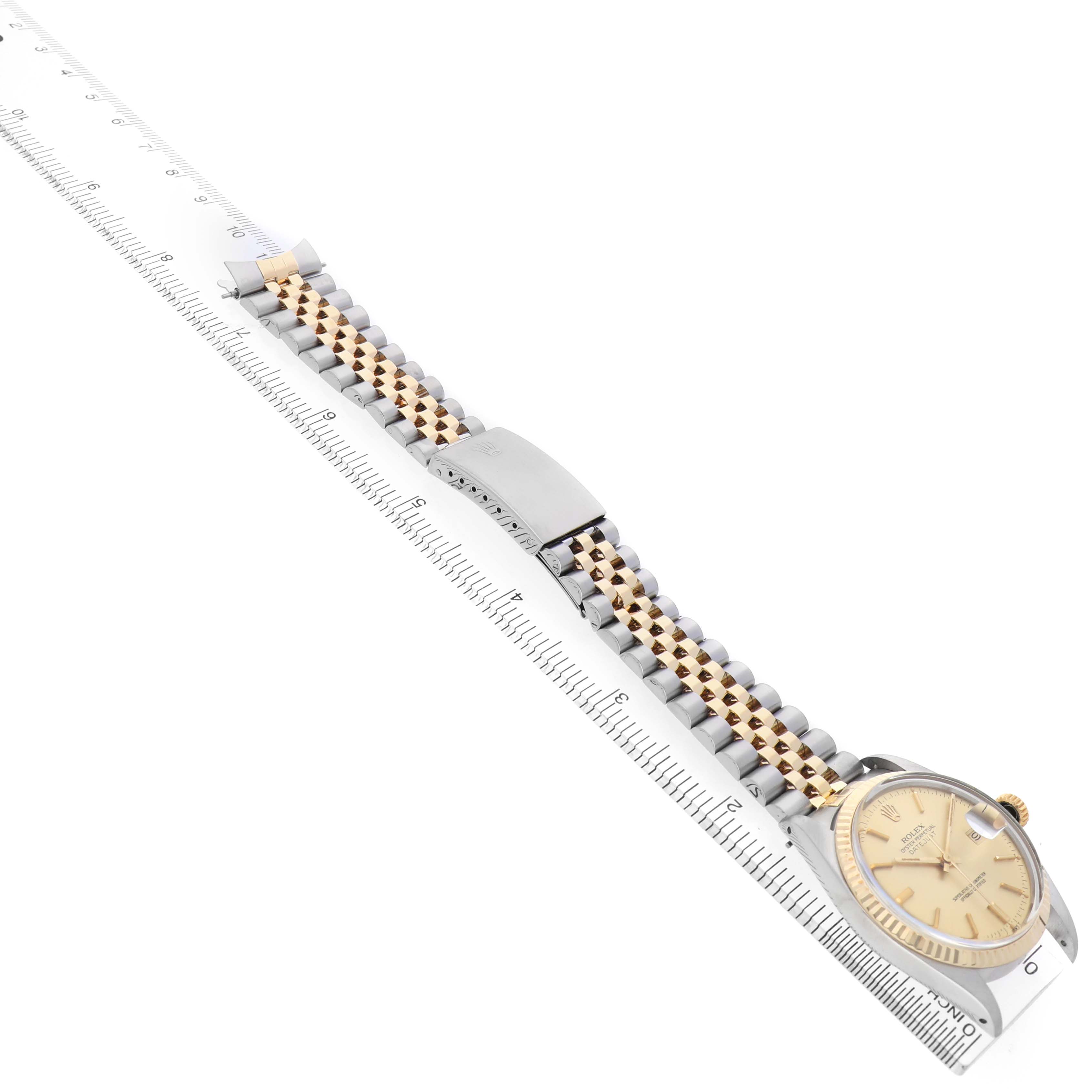 The Rolex Datejust 16013 Men's Steel and Gold (two tone) Champagne Dial watch is shown from a slightly elevated side angle, highlighting the face, bezel, and jubilee bracelet.