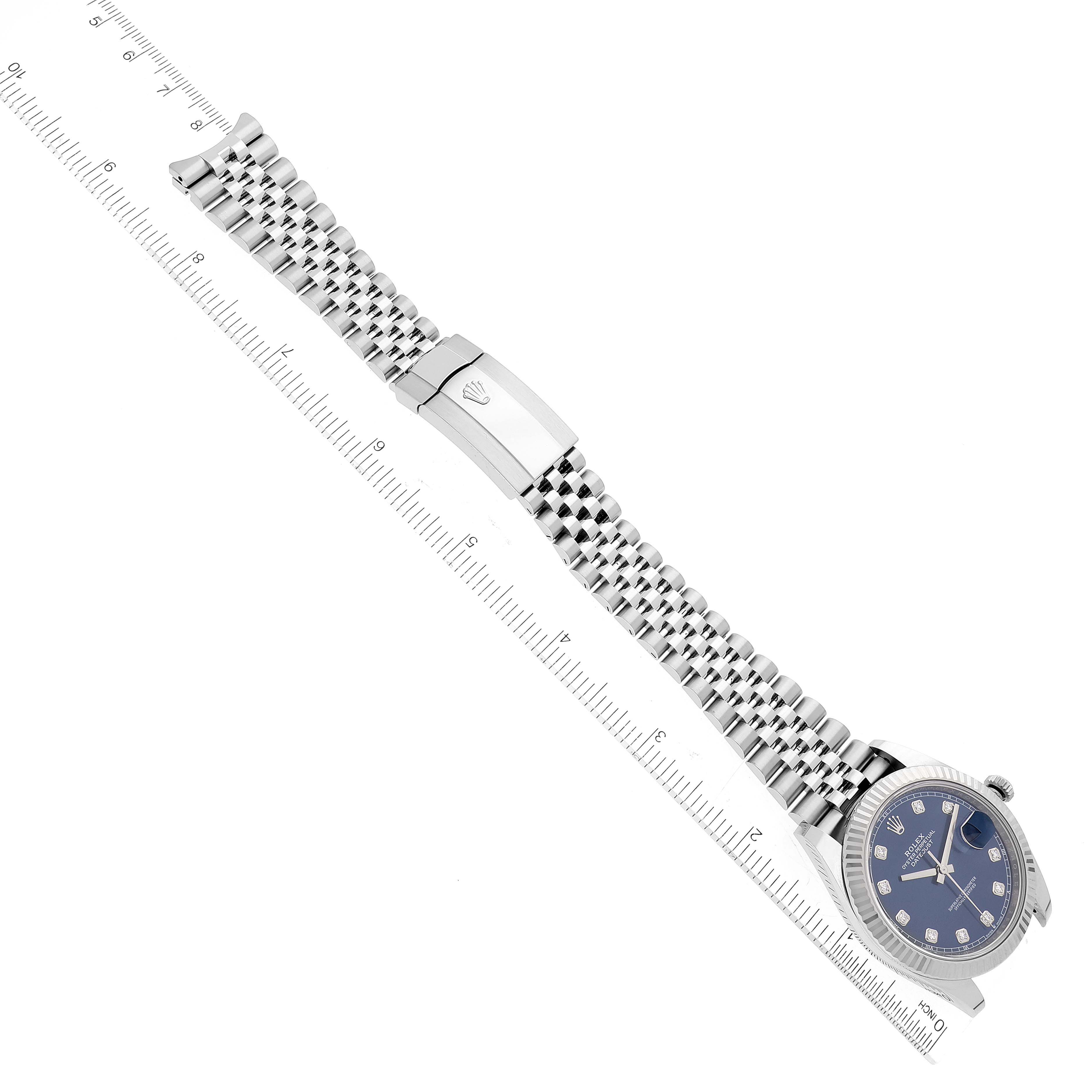 This image shows the Rolex Datejust 41 126334 Men
s Stainless Steel Blue Dial 126334 Men
s Stainless Steel Blue Dial watch laid out flat, highlighting the dial, bracelet, and clasp, with a ruler in the background.