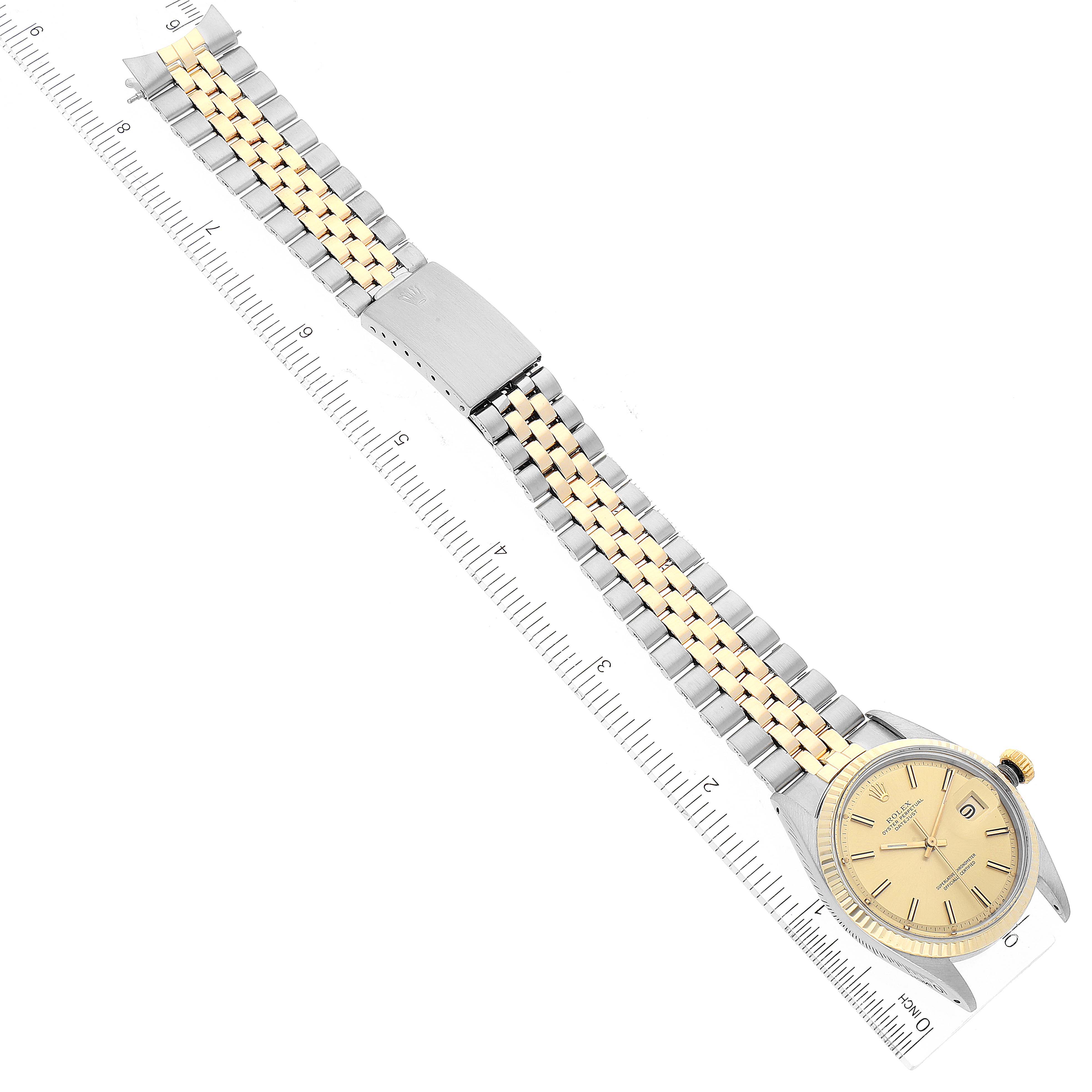 The Rolex Datejust 1601 Men
s Steel and Gold (two tone) Champagne Dial 1601 Men
s Steel and Gold (two tone) Champagne Dial watch is shown laid flat, displaying the full band, clasp, and watch face, measured alongside a ruler.
