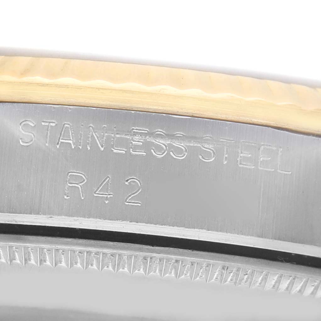 The image shows a close-up side view of a Rolex Datejust 68273 Women's Steel and Gold (two tone) Champagne Dial, focusing on the engraved stainless steel case.