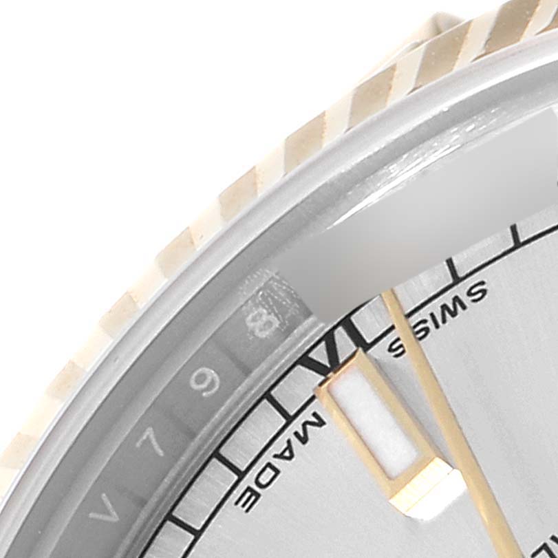 This close-up image of a Rolex Mid-Size 178273 Women
s Steel and Gold (two tone) Silver Dial 178273 Women
s Steel and Gold (two tone) Silver Dial watch shows a partial view of the face, the 
SWISS MADE
 text, and the bezel.
