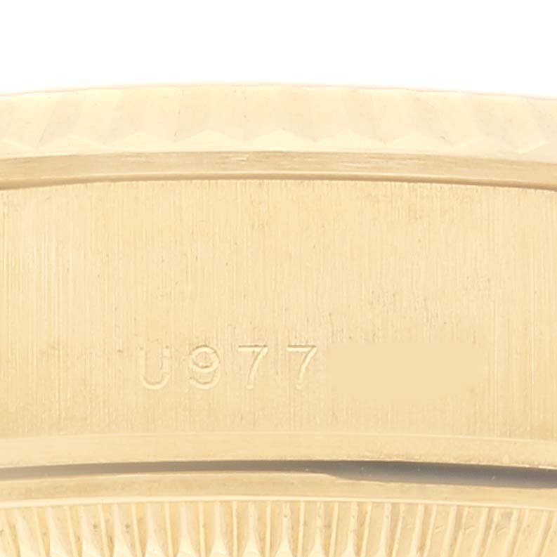 This image shows a close-up of the side of a Rolex President 69178 Women
s Yellow Gold Champagne Dial 69178 Women
s Yellow Gold Champagne Dial model watch, displaying part of the bezel and case along with an engraved serial number.