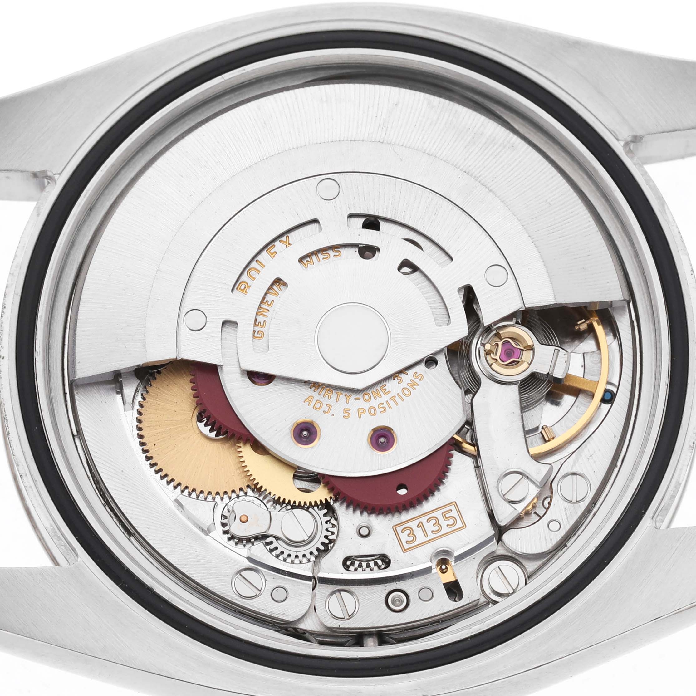 The image shows the internal movement of a Rolex Datejust 116234 Men's Stainless Steel Silver Dial watch viewed from the back, highlighting the gears and mechanisms.