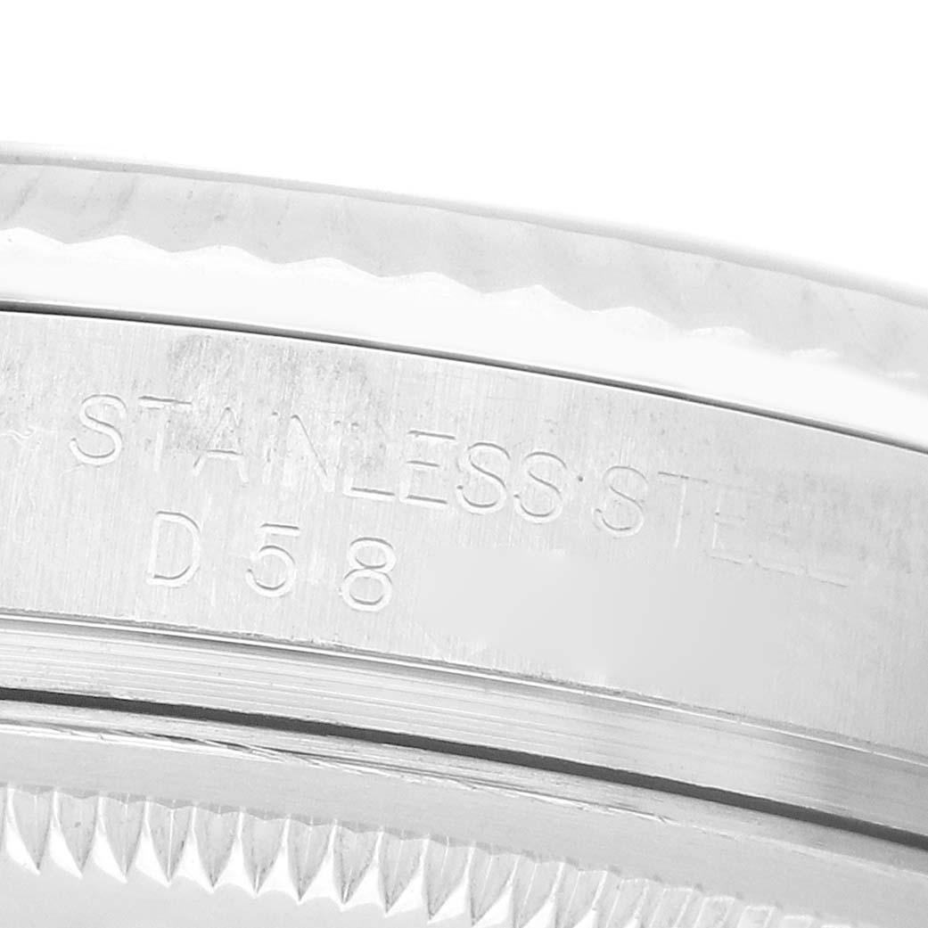 The image shows a close-up of the side of a Rolex Datejust 116234 Men's Stainless Steel Silver Dial watch, focusing on the bezel edge and engraved "STAINLESS STEEL" text.