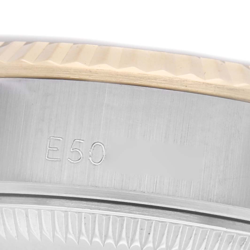 The image shows a close-up of the side of a Rolex Datejust 69173 Women
s Steel and Gold (two tone) Silver Dial 69173 Women
s Steel and Gold (two tone) Silver Dial, focusing on the fluted bezel and engraved case markings.