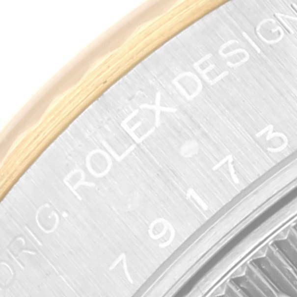 This close-up image shows the edge and part of the engraved dial of a Rolex Datejust 79173 Women's Steel and Gold (two tone) Black Dial 79173 Women's Steel and Gold (two tone) Black Dial watch.
