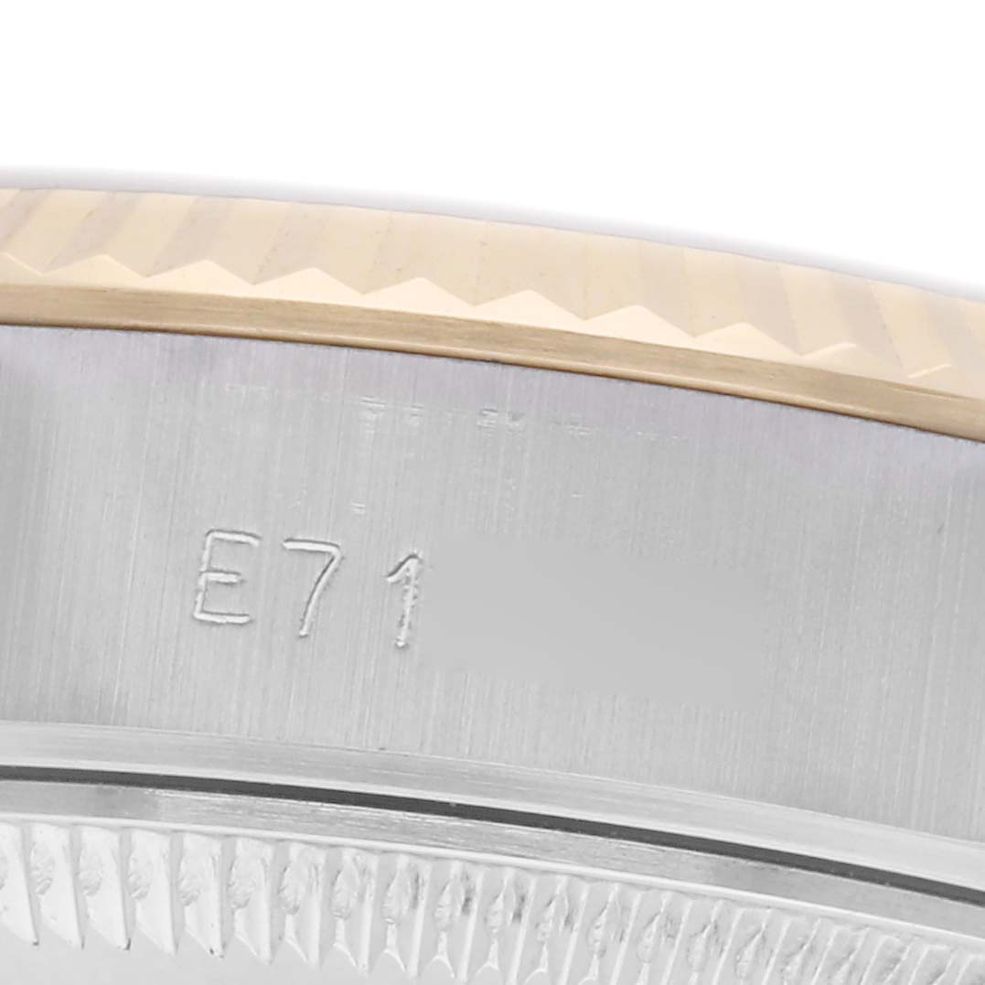 The image shows a close-up of the side of the Rolex Datejust 69173 Women
s Steel and Gold (two tone) Champagne Dial 69173 Women
s Steel and Gold (two tone) Champagne Dial, highlighting the fluted bezel and part of the engraved serial number.