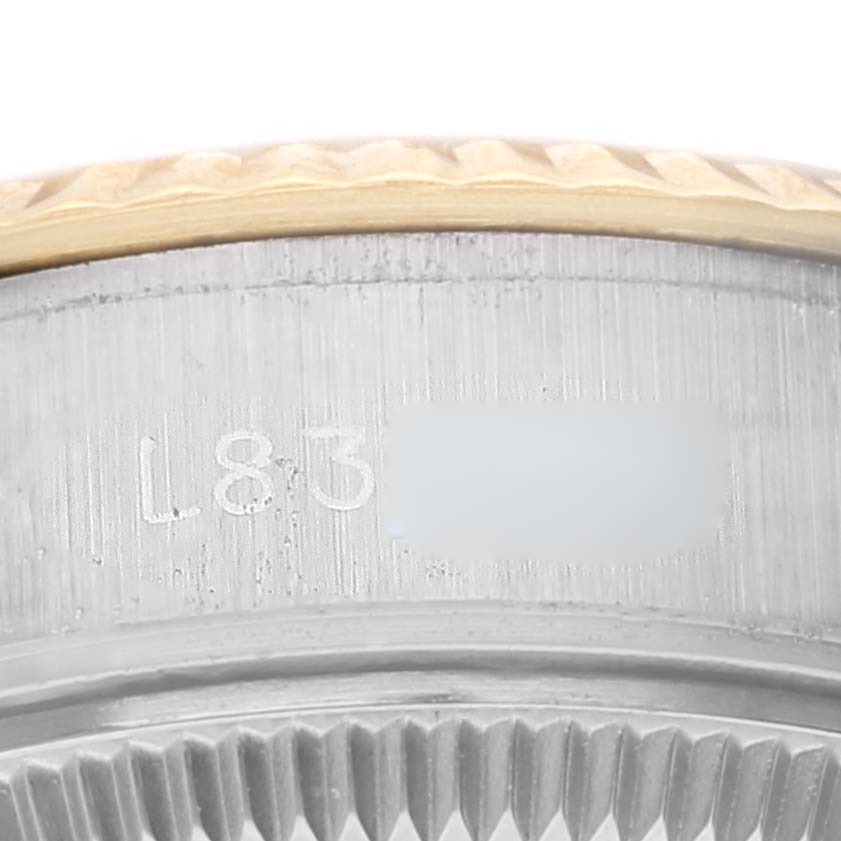 This is a close-up of the casing of a Rolex Datejust 69173 Women's Steel and Gold (two tone) Champagne Dial 69173 Women's Steel and Gold (two tone) Champagne Dial watch, emphasizing the serial engraving and the edge of the bezel.