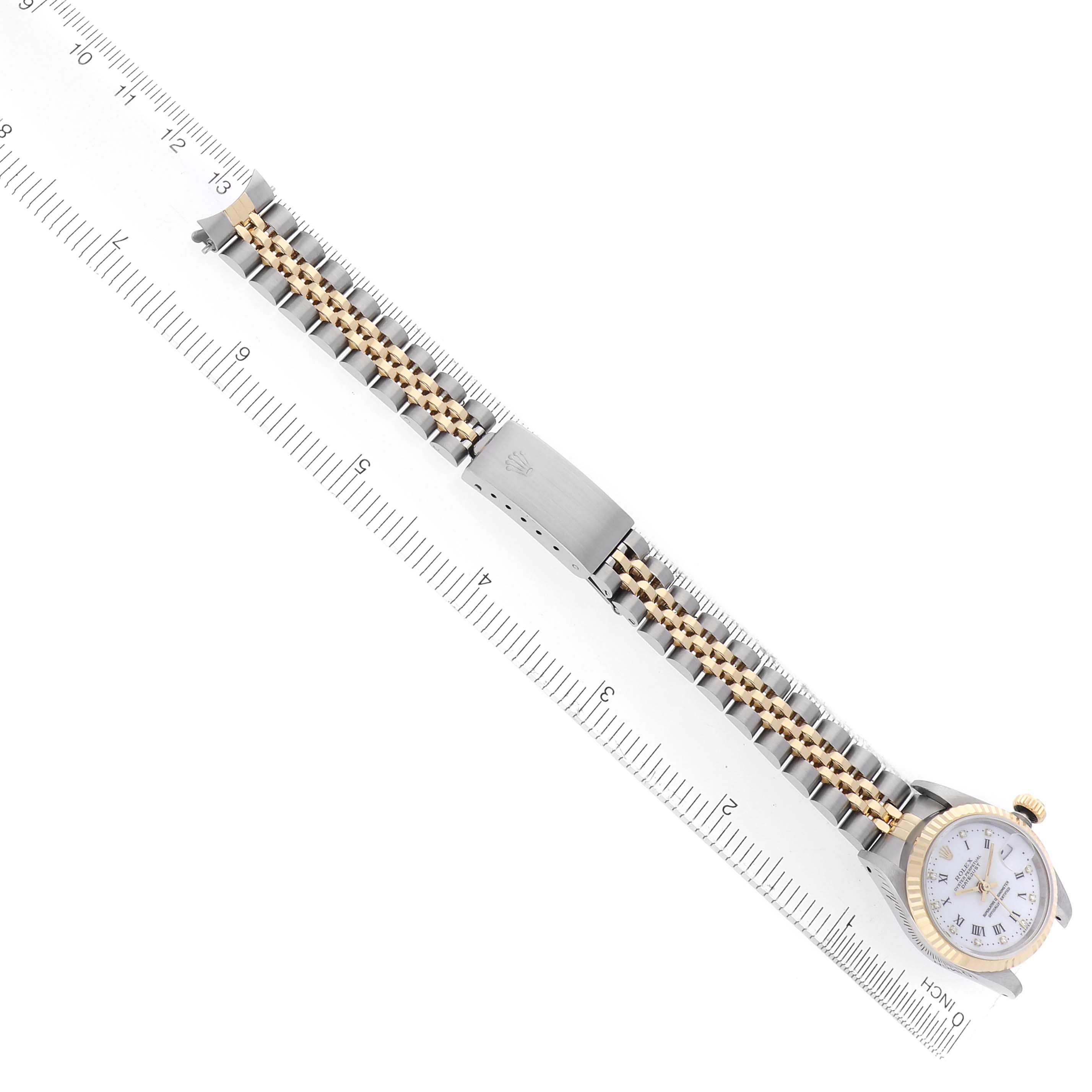 The Rolex Datejust 69173 Women
s Steel and Gold (two tone) White Dial 69173 Women
s Steel and Gold (two tone) White Dial watch is shown flat, highlighting the full bracelet and clasp alongside a ruler for scale.