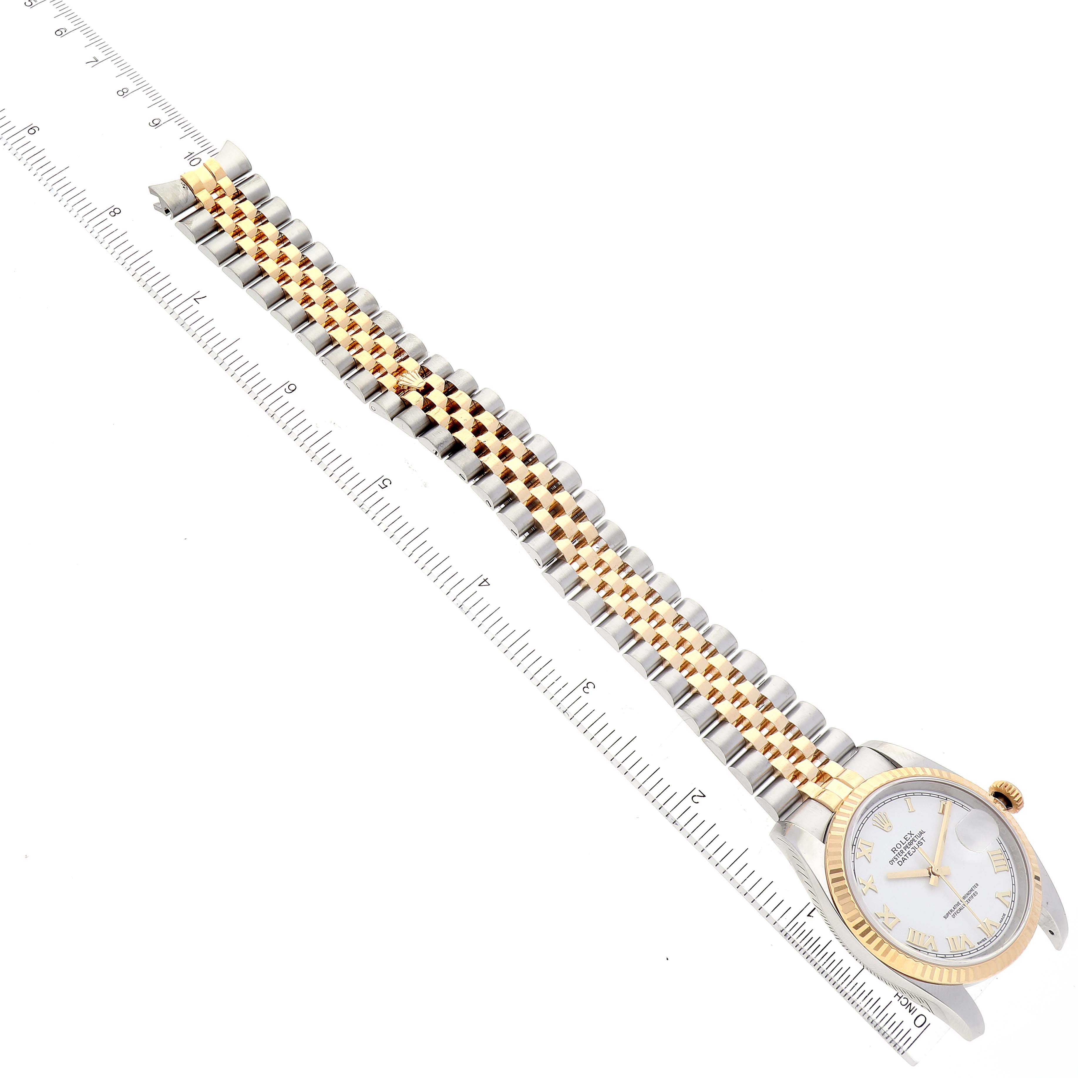 This image shows the Rolex Datejust 116233 Men's Steel and Gold (two tone) White Dial 116233 Men's Steel and Gold (two tone) White Dial watch from an angled top view with its face and two-tone bracelet visible alongside a ruler.
