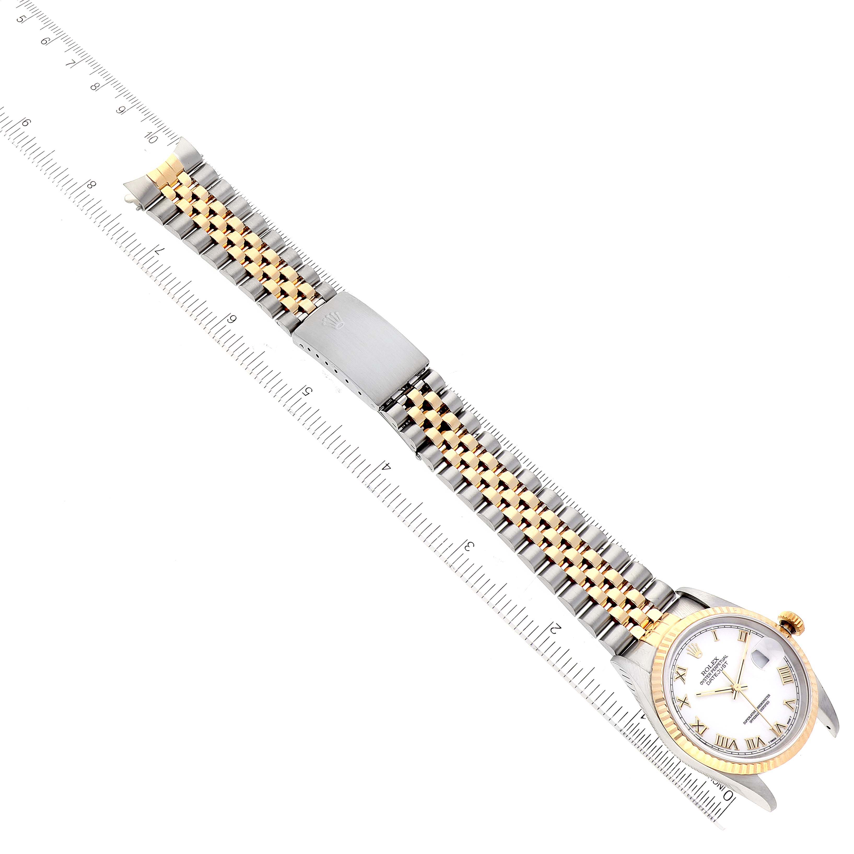This image shows a Rolex Datejust 16233 Men's Steel and Gold (two tone) White Dial 16233 Men's Steel and Gold (two tone) White Dial watch laid flat with a ruler measuring its metal and gold jubilee bracelet.