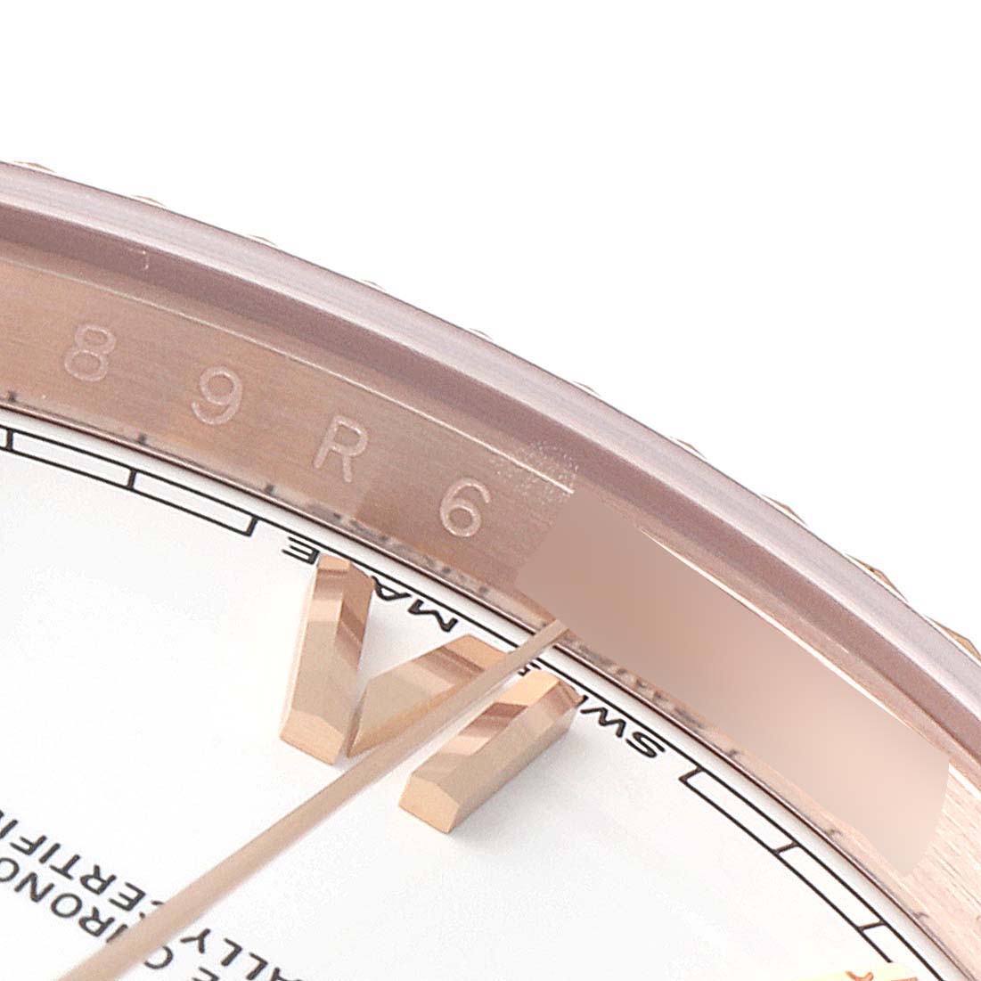This close-up image shows part of the dial and bezel engraving of a Rolex President 228235 Men's Rose Gold White Dial 228235 Men's Rose Gold White Dial model watch.