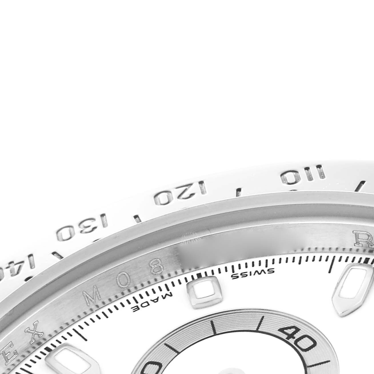 The image shows a close-up of the bezel and partial dial of a Rolex Daytona 116520 Men
s Stainless Steel White Dial 116520 Men
s Stainless Steel White Dial watch, viewed from an angled perspective.