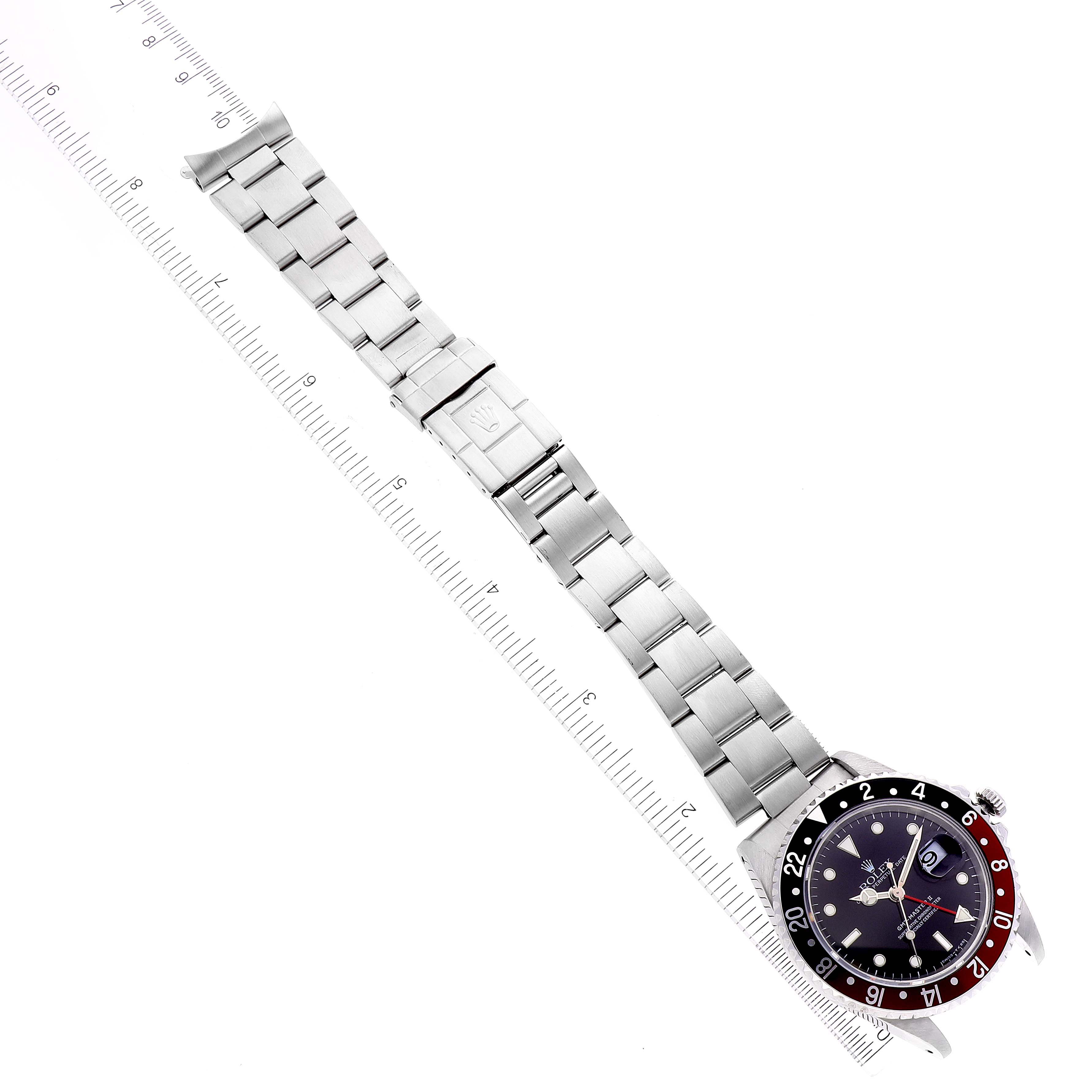 The Rolex GMT-Master 16710 Men's Stainless Steel Black Dial 16710 Men's Stainless Steel Black Dial watch is shown flat from above, displaying the face, bezel, and complete metal bracelet alongside a ruler.