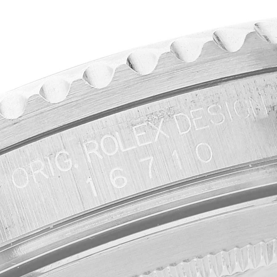 This is a close-up view of the bezel and case side of a Rolex GMT-Master 16710 Men's Stainless Steel Black Dial 16710 Men's Stainless Steel Black Dial model, showcasing its serial number and design engraving.