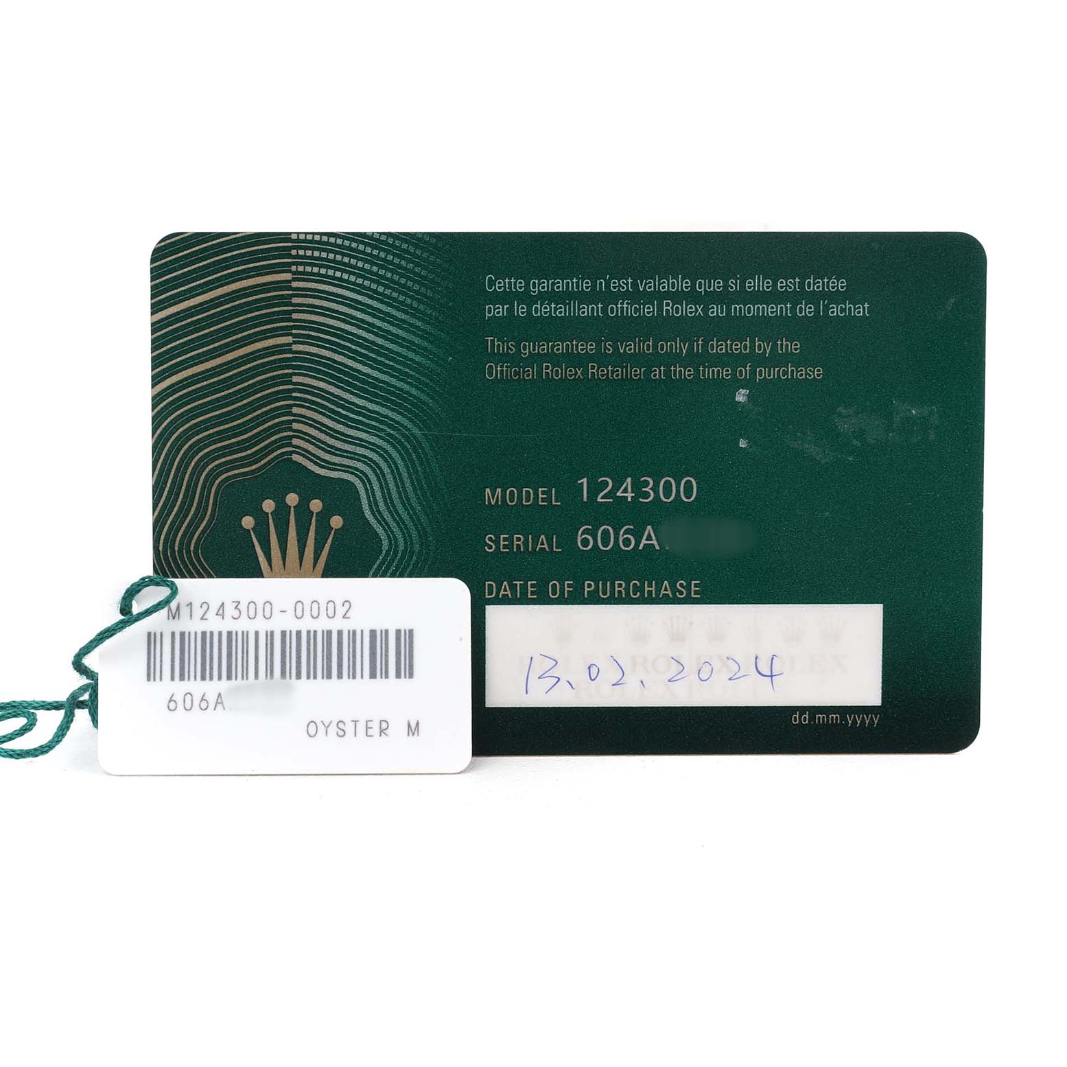 The image shows a Rolex Oyster Perpetual M124300-0002 Men's Stainless Steel Black Dial model 124300 warranty card and a tag with model and serial information.