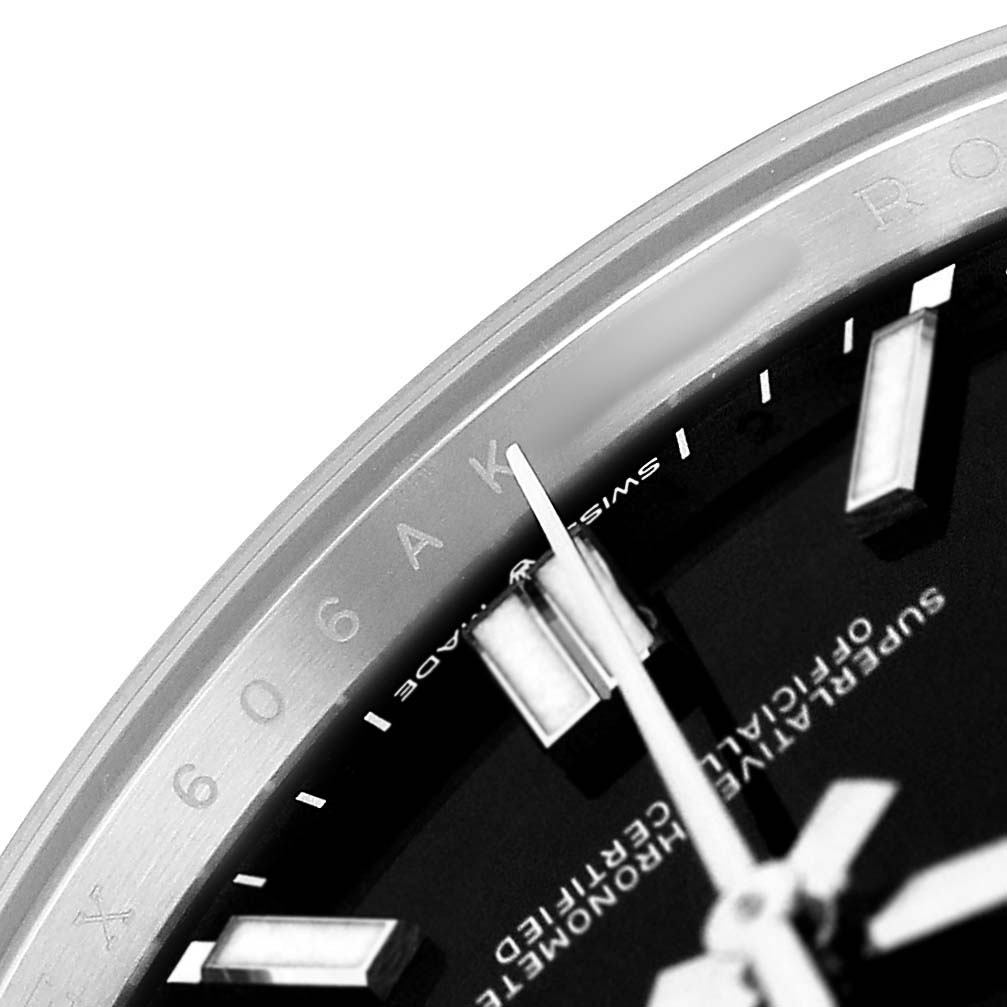 The image shows a close-up of the Rolex Oyster Perpetual M124300-0002 Men's Stainless Steel Black Dial watch face, focusing on parts of the dial, indices, and inner bezel markings.