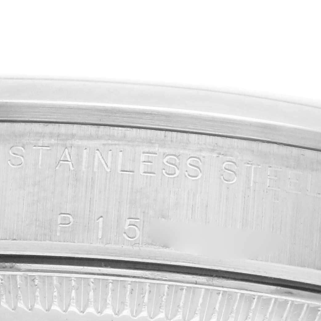 The image shows a close-up of the case back edge of the Rolex Mid-Size 77080 Women
s Stainless Steel White Dial 77080 Women
s Stainless Steel White Dial model, highlighting "Stainless Steel" engraving.