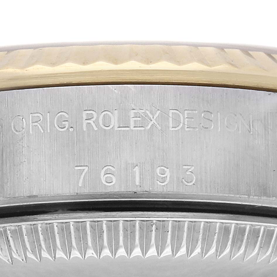 The image shows a close-up of the side of a Rolex Oyster Perpetual 76193 Women
s Steel and Gold (two tone) Champagne Dial 76193 Women
s Steel and Gold (two tone) Champagne Dial watch, highlighting the engraved model number and design.