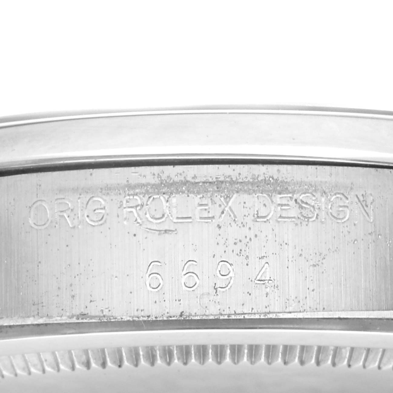 The image shows the side of a Rolex Vintage Collection 6694 Men
s Stainless Steel Silver Dial 6694 Men
s Stainless Steel Silver Dial model, focusing on the engraved design and model number.