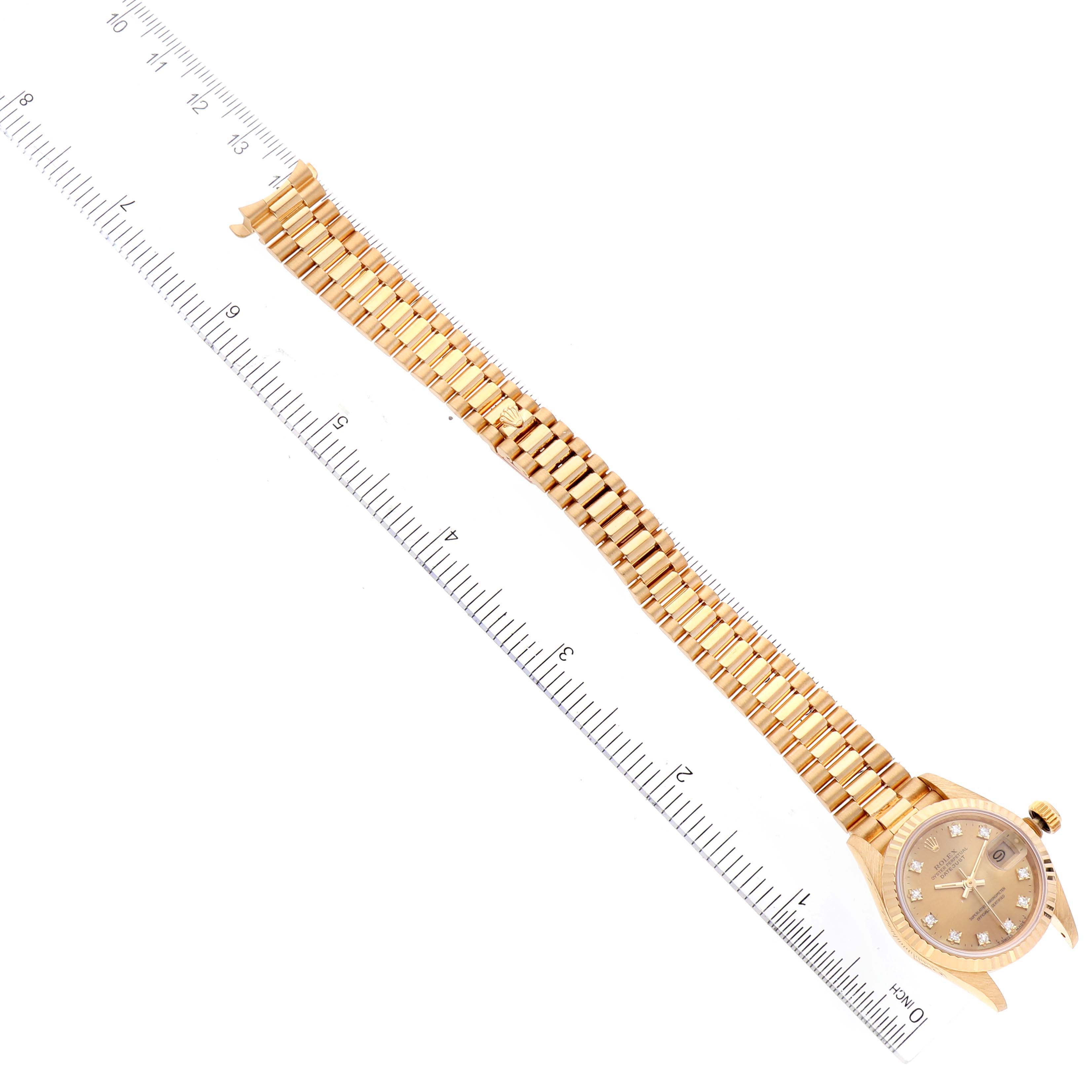 The image shows a Rolex President 69178 Women
s Yellow Gold Champagne Dial 69178 Women
s Yellow Gold Champagne Dial watch lying flat, displaying the dial, case, and bracelet against a measuring scale.