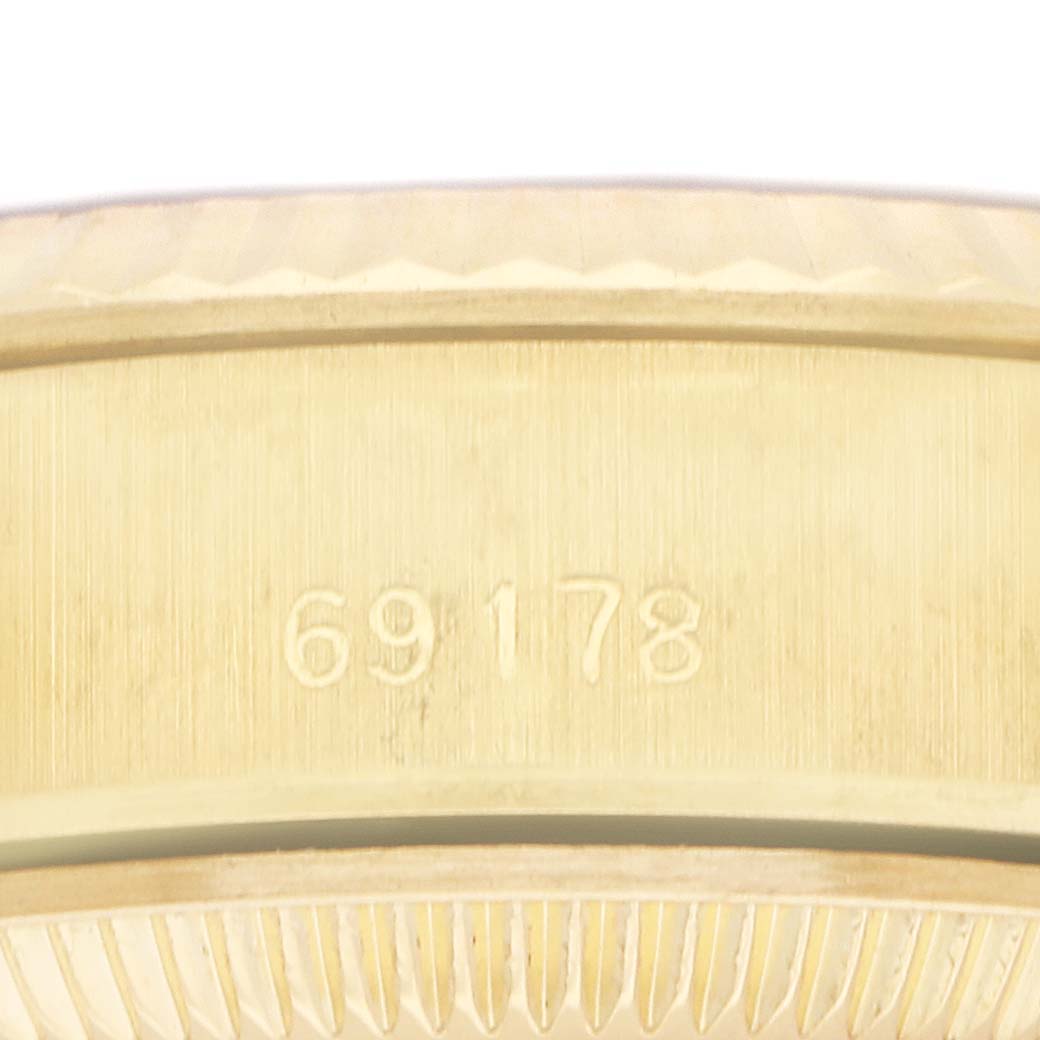 The image shows a close-up of the side of the Rolex President 69178 Women
s Yellow Gold Champagne Dial 69178 Women
s Yellow Gold Champagne Dial watch, focusing on the serial number engraving.