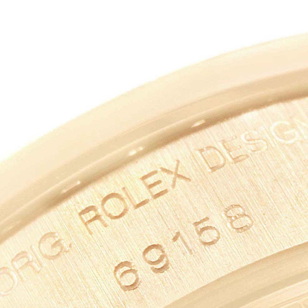 This close-up image shows the engraved serial numbers on the case back rim of the Rolex President 69158 Women's Yellow Gold Black Dial 69158 Women's Yellow Gold Black Dial model watch.